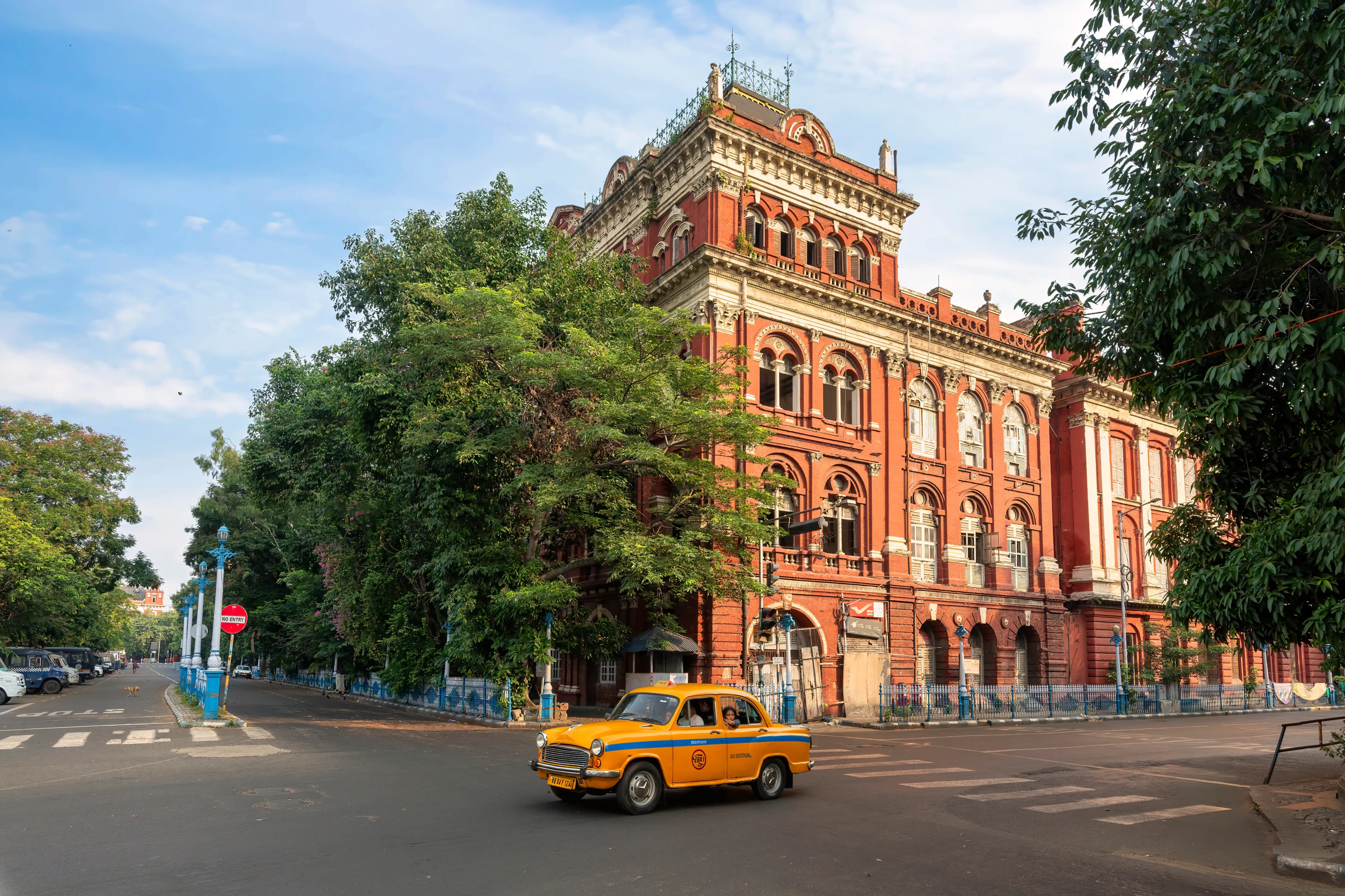 Ancient Writers' Building built in the colonial era with a view of a yellow taxi on the city road in the morning in Kolkata, India, photographed on July 3, 2024