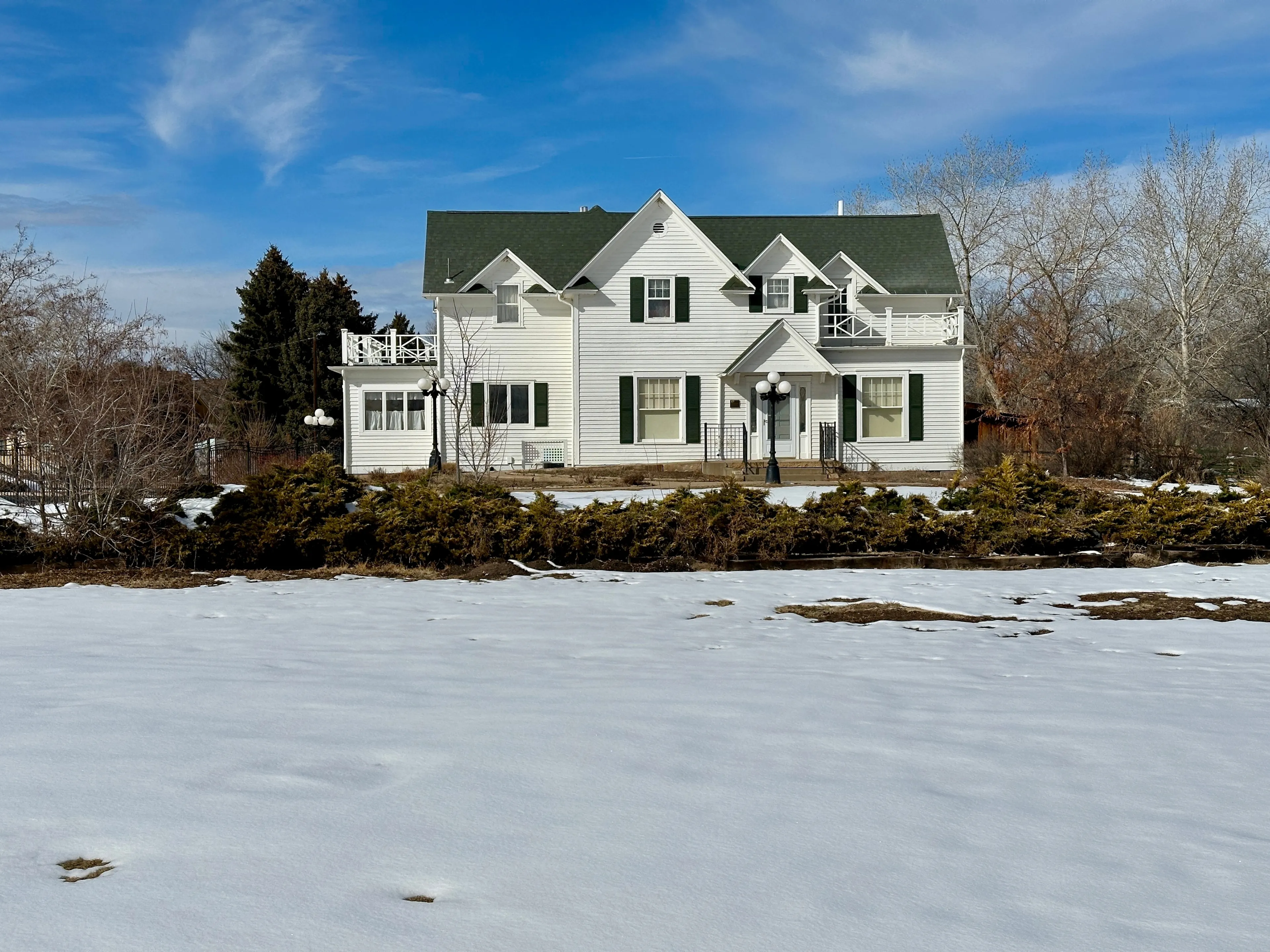 Greeley, Colorado, USA - February 18, 2024: House with large yard covered with snow. Located at The Centennial Village Museum.