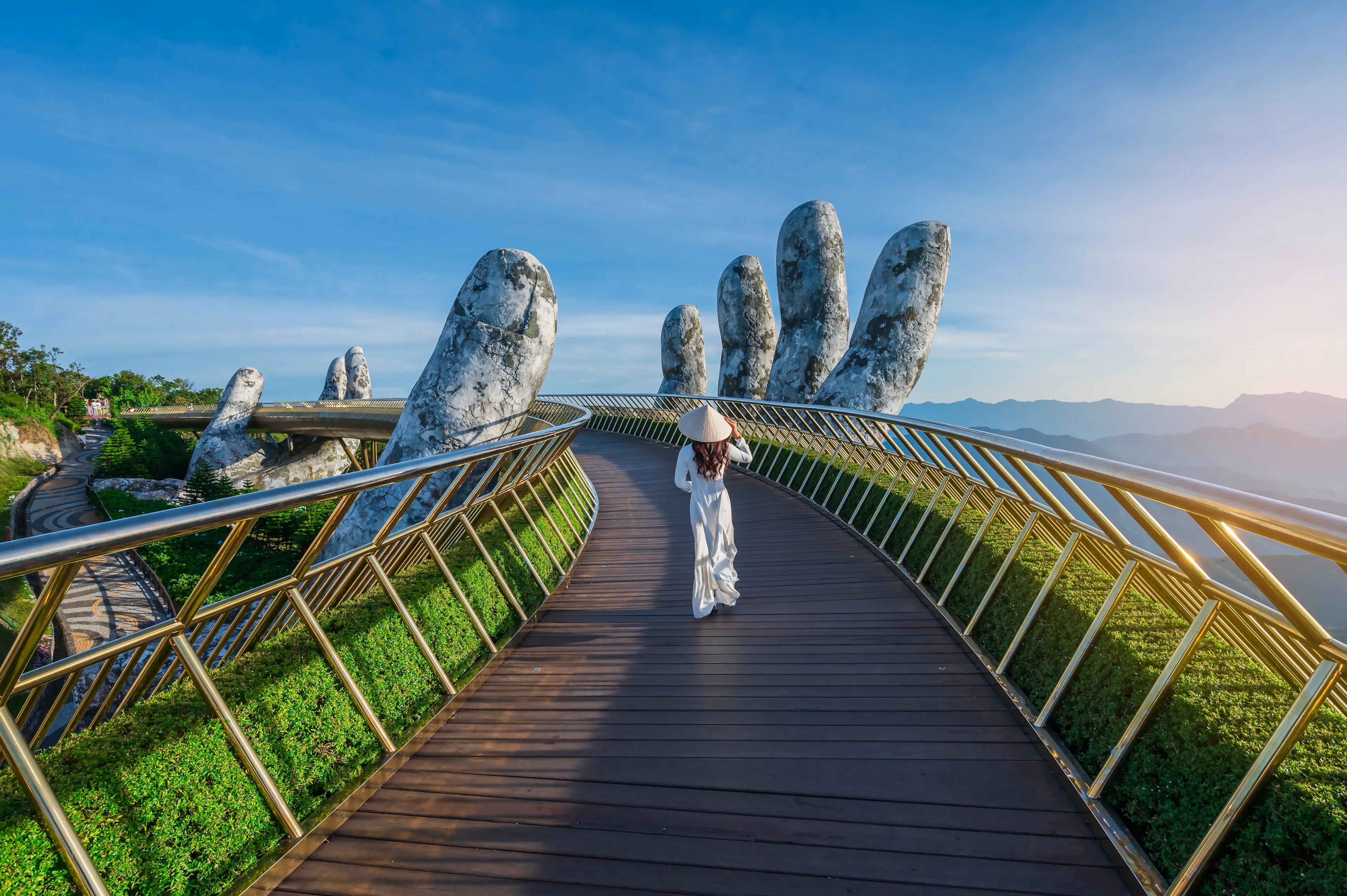 Vietnamese girl with traditional dress (ao dai) on Golden bridge at the top of the Ba Na Hills, Vietnam