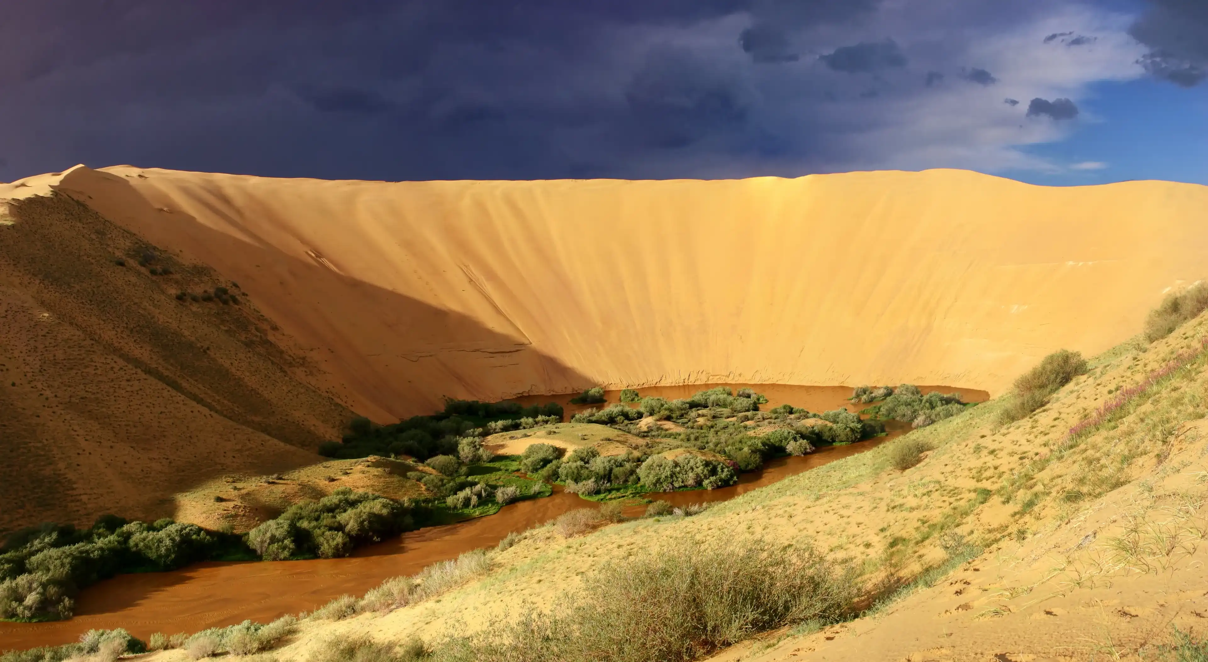 Mukhart River sources out of Great Mongol desert towers 450 m above the surrounding plain. Mukhart River sources out of Great Mongol desert towers 450 m above the surrounding plain.