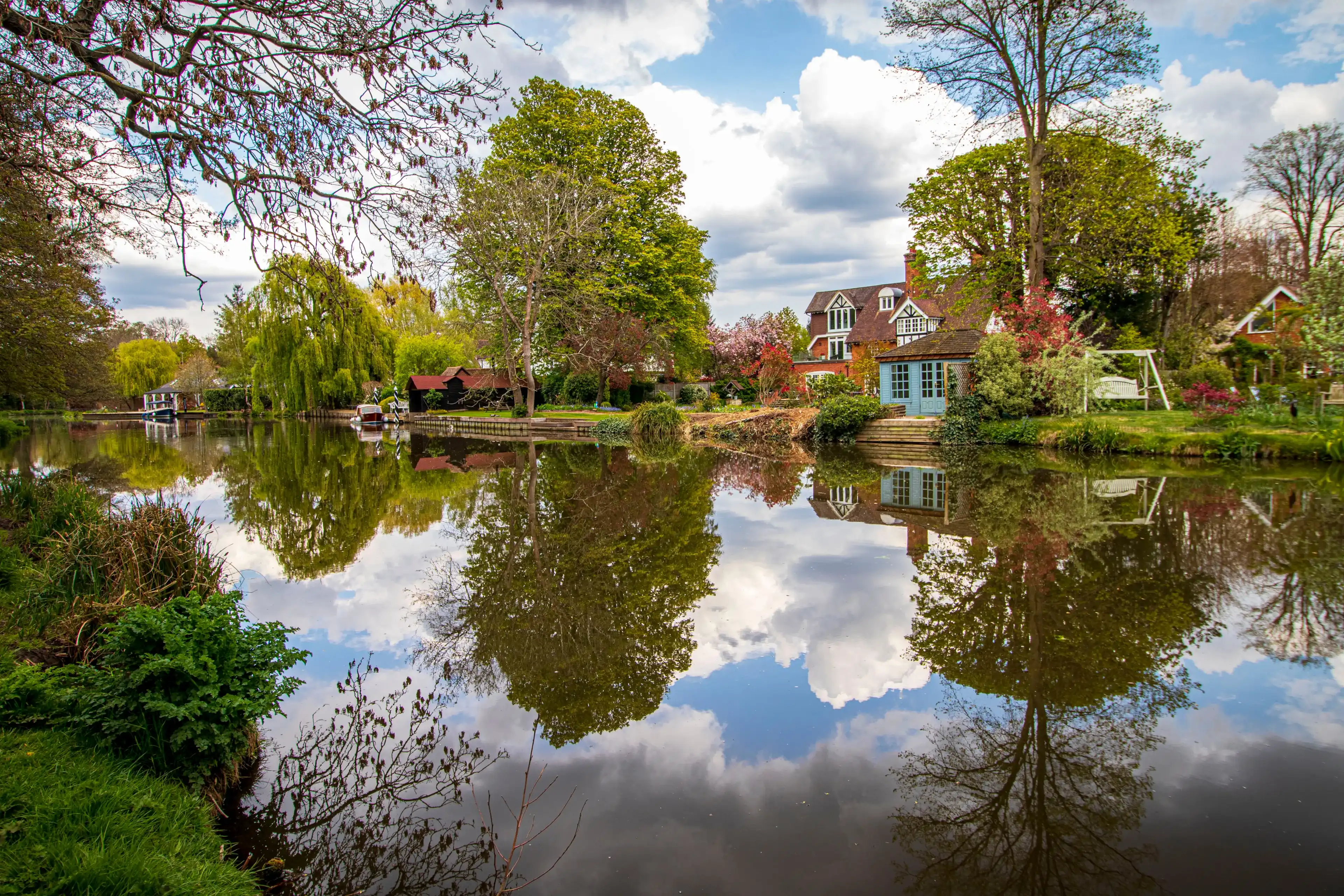 Beautiful England.View of houses and boats reflected in Wey river water. Weybridge 01 04 2021 Beautiful England.View of houses and boats reflected in Wey river water. Weybridge 01 04 2021