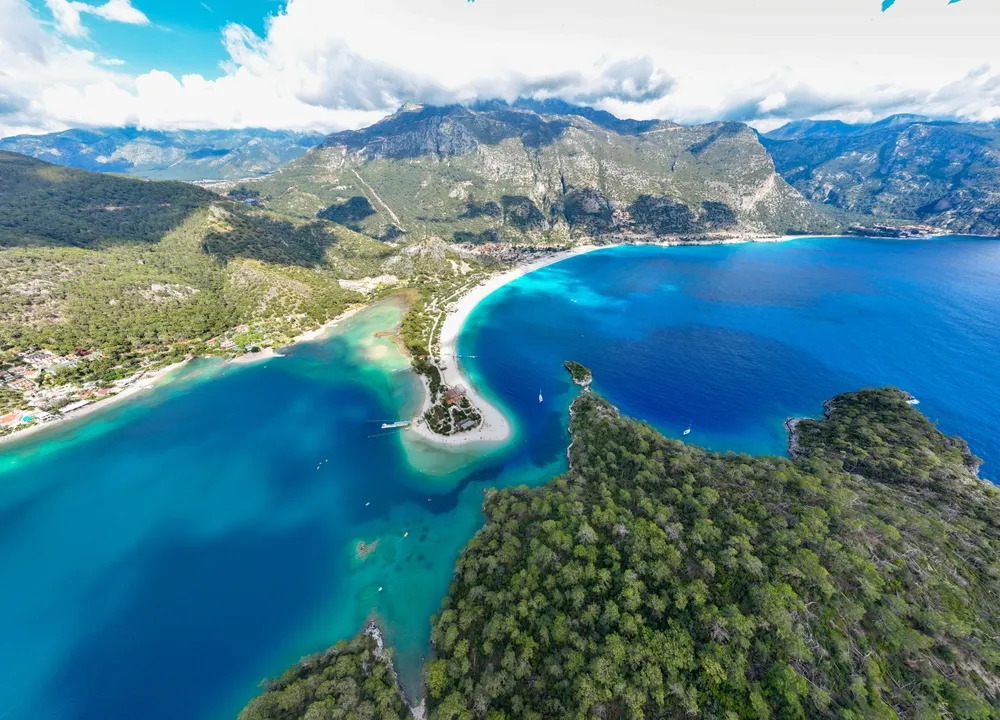 Drone showcases the stunning Ölüdeniz beach and bay in Fethiye, Muğla, Turkey. The breathtaking view is a testament to Turkey's natural allure.