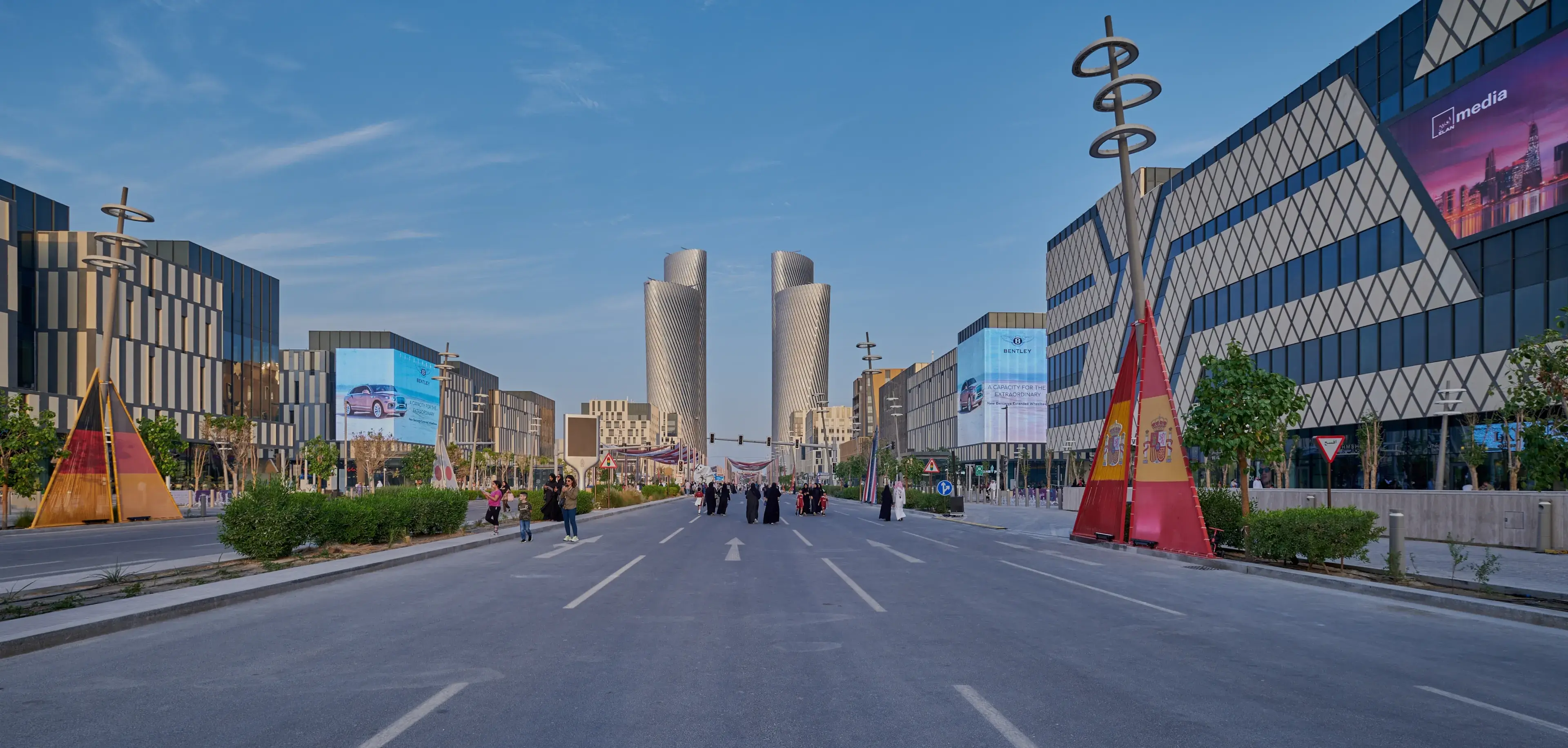 Lusail city, Qatar- November 12 2022: Lusail boulevard afternoon shot showing Qatar preparation for FIFA World Cup 2022 with flags of participating counties and locals and visitors walking. Lusail city, Qatar- November 12 2022: Lusail boulevard afternoon shot showing Qatar preparation for FIFA World Cup 2022 with flags of participating counties and locals and visitors walking.