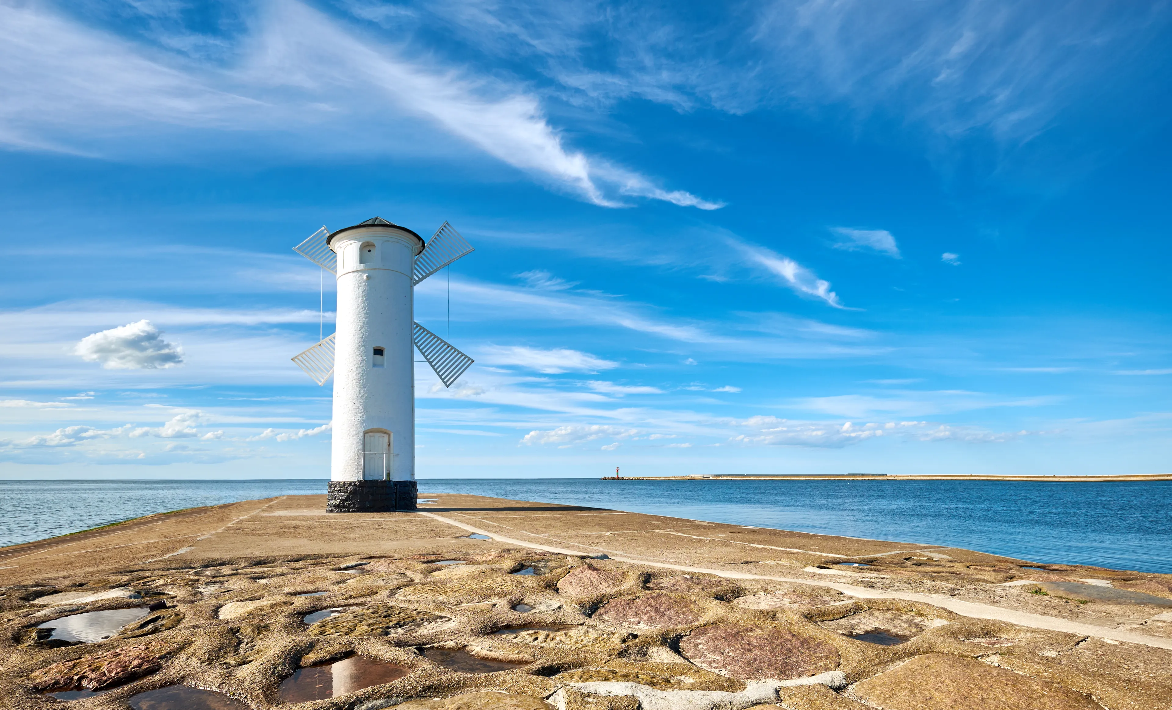 Panoramic image of seawall and retro windmill lighthouse in Swinoujscie, a port in Poland on the Baltic Sea.