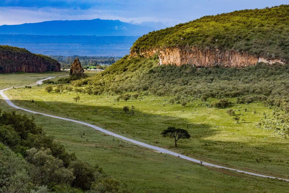 Hell's Gate National Park Gorge Escarpments Filled with greenery vegetation on a cloudy blue sky in Naivasha Great Rift Valley Nakuru City County Kenya East Africa, Kenya Landscapes Travel Documentary