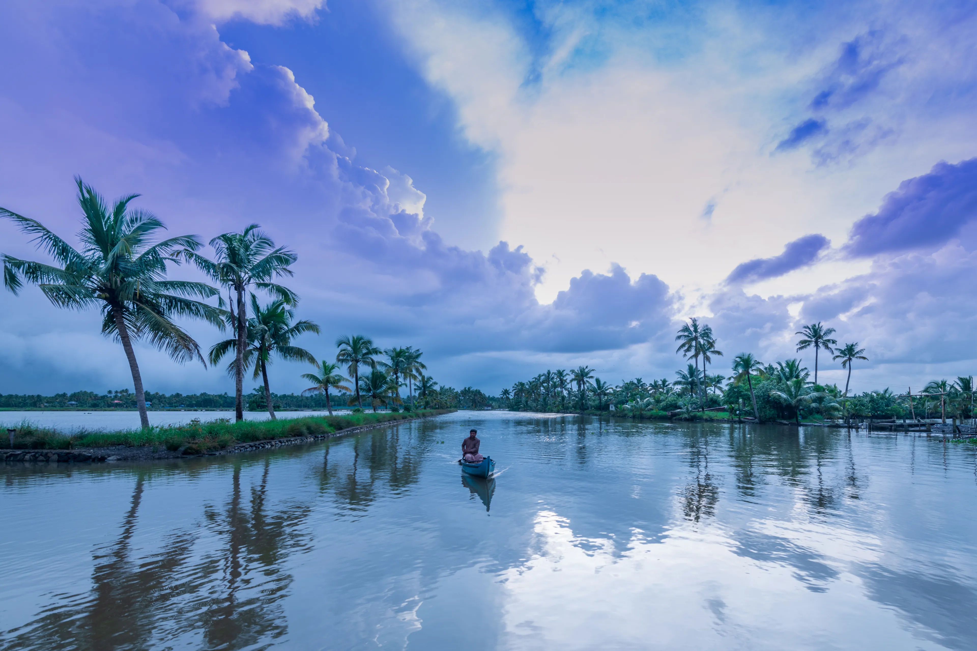 Kadamakkudy, Ernakulam, India - February7,  2020, Morning view of backwaters, coconut trees and fisher man in Kerala boat on a Cloudy day 