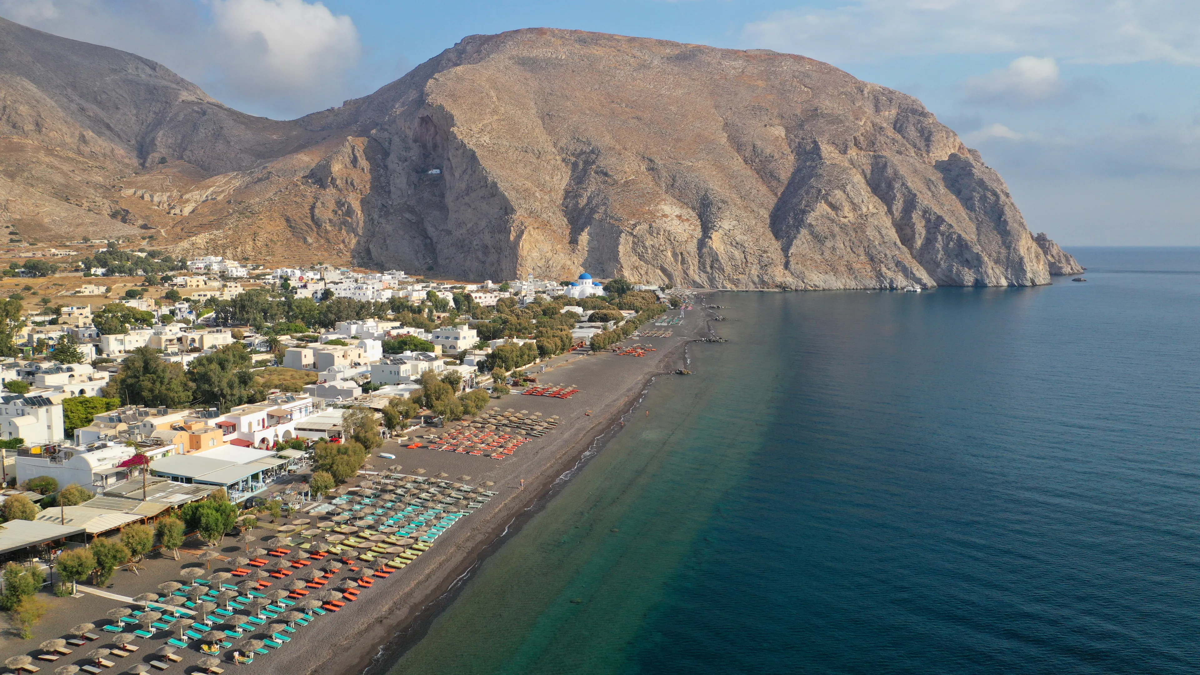 Aerial drone photo of famous volcanic beach and bay of Perissa village, Santorini island, Cyclades, Greece