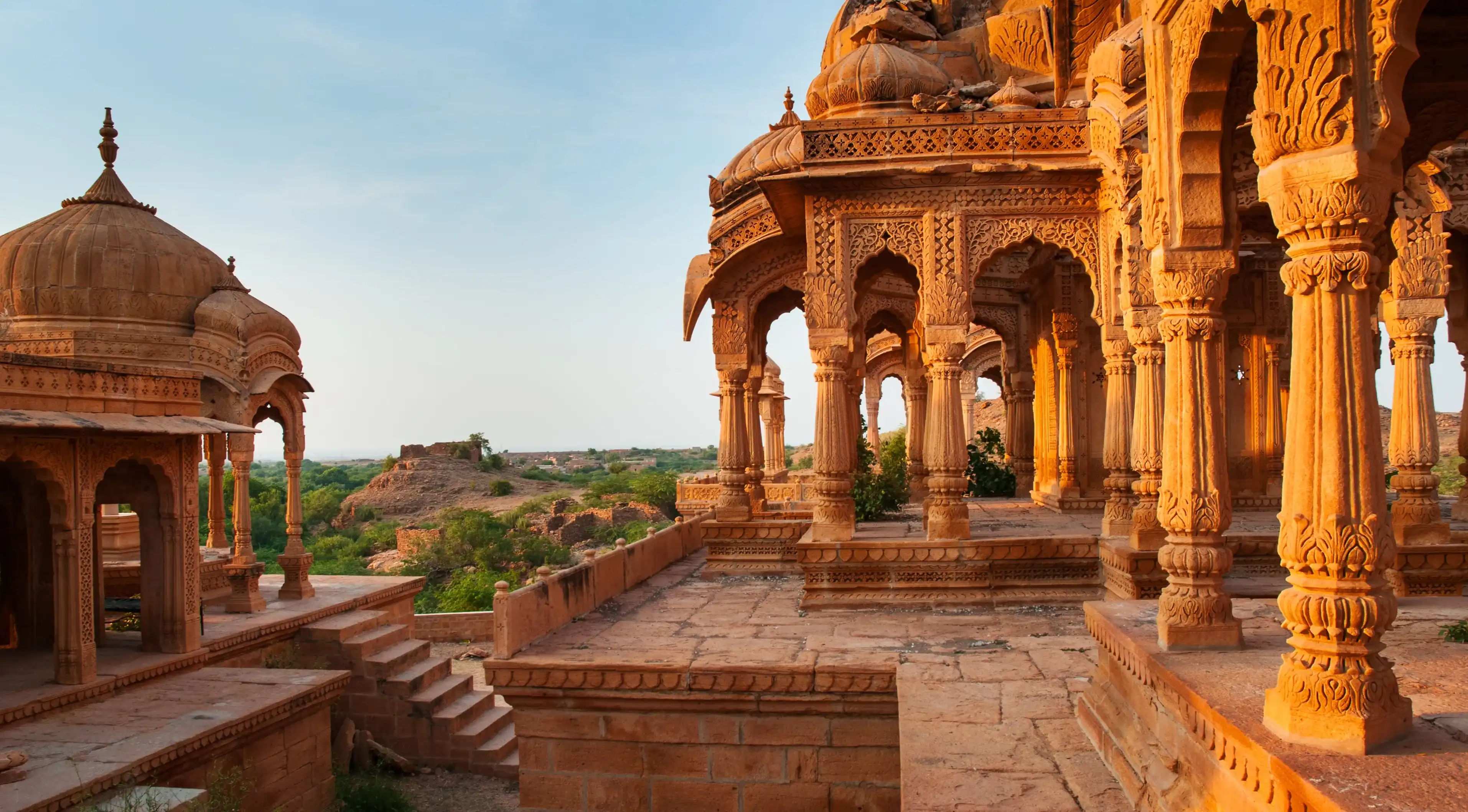 The royal cenotaphs of historic rulers, also known as Jaisalmer Chhatris, at Bada Bagh in Jaisalmer, Rajasthan, India. Cenotaphs made of yellow sandstone at sunset The royal cenotaphs of historic rulers, also known as Jaisalmer Chhatris, at Bada Bagh in Jaisalmer, Rajasthan, India. Cenotaphs made of yellow sandstone at sunset
