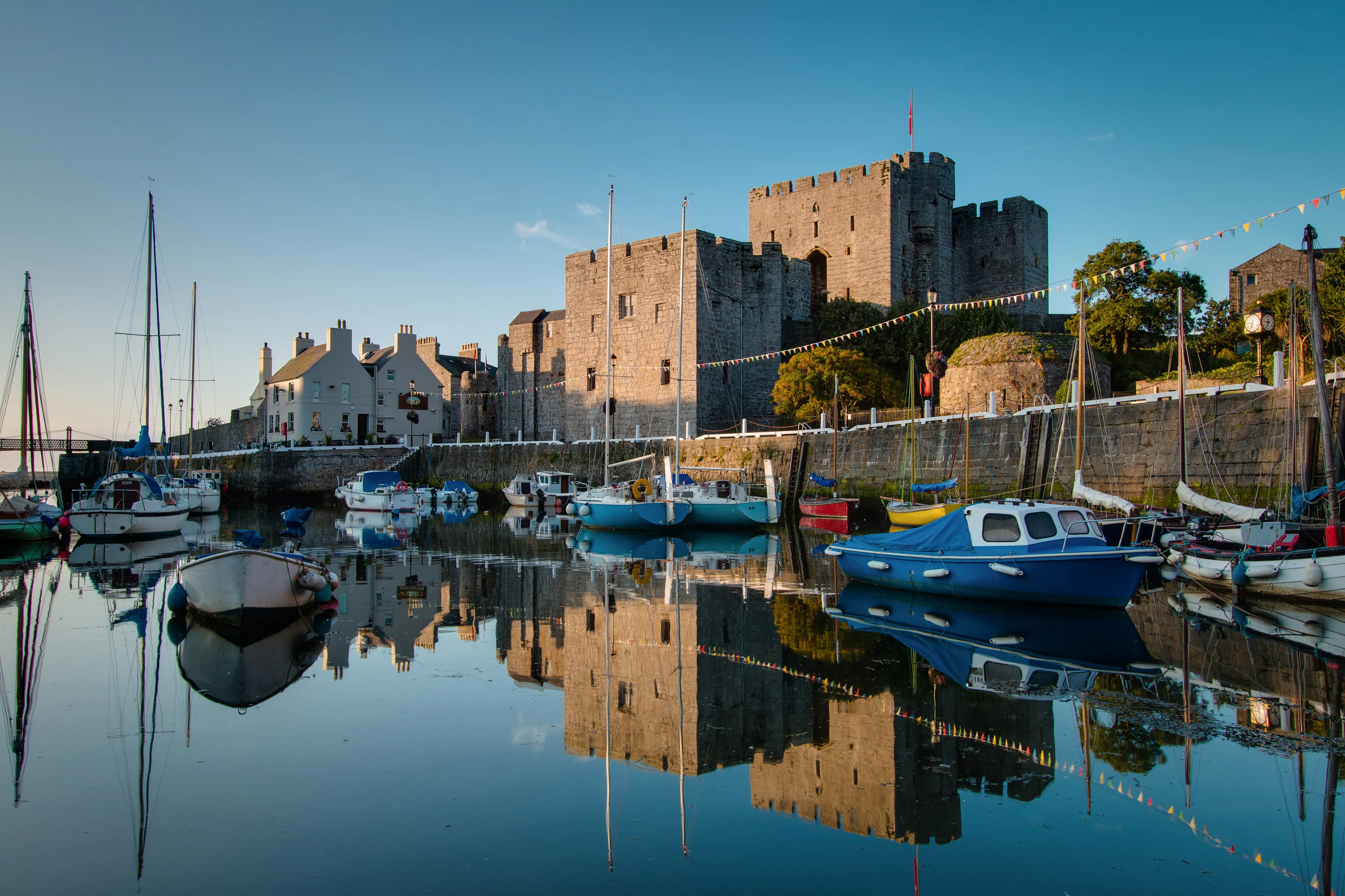 Castle Rushen in Castletown in the Isle of Man, with reflections in the harbor - taken shortly after sunrise