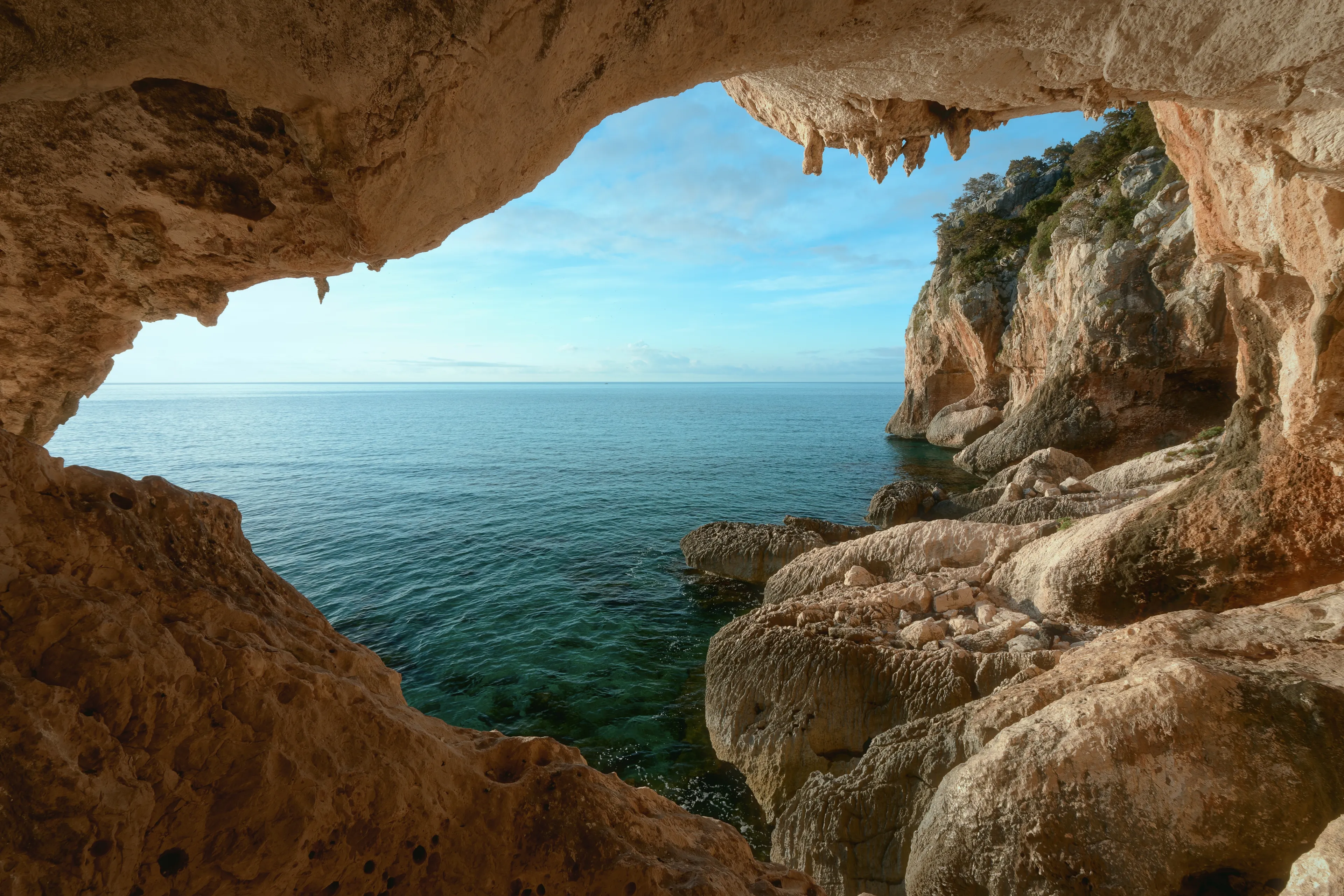 The view from the cave to rocky coast near Cala Gonone, Sardinia. Italy. Vacation travel holiday banner, summer mood.