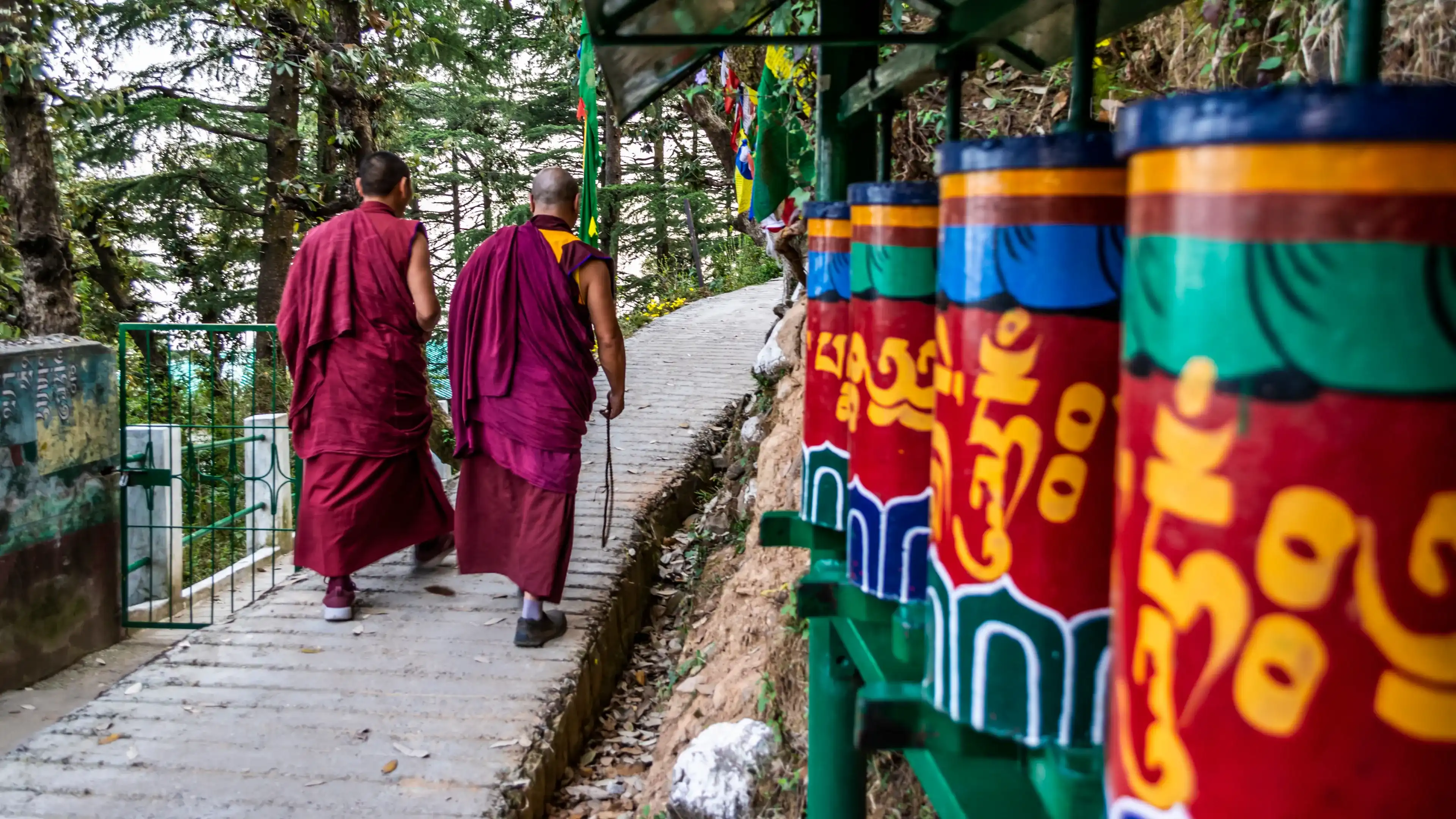 Tibetan Monks walking among praying wheels, Dharamsala, India Tibetan Monks walking among praying wheels, Dharamsala, India