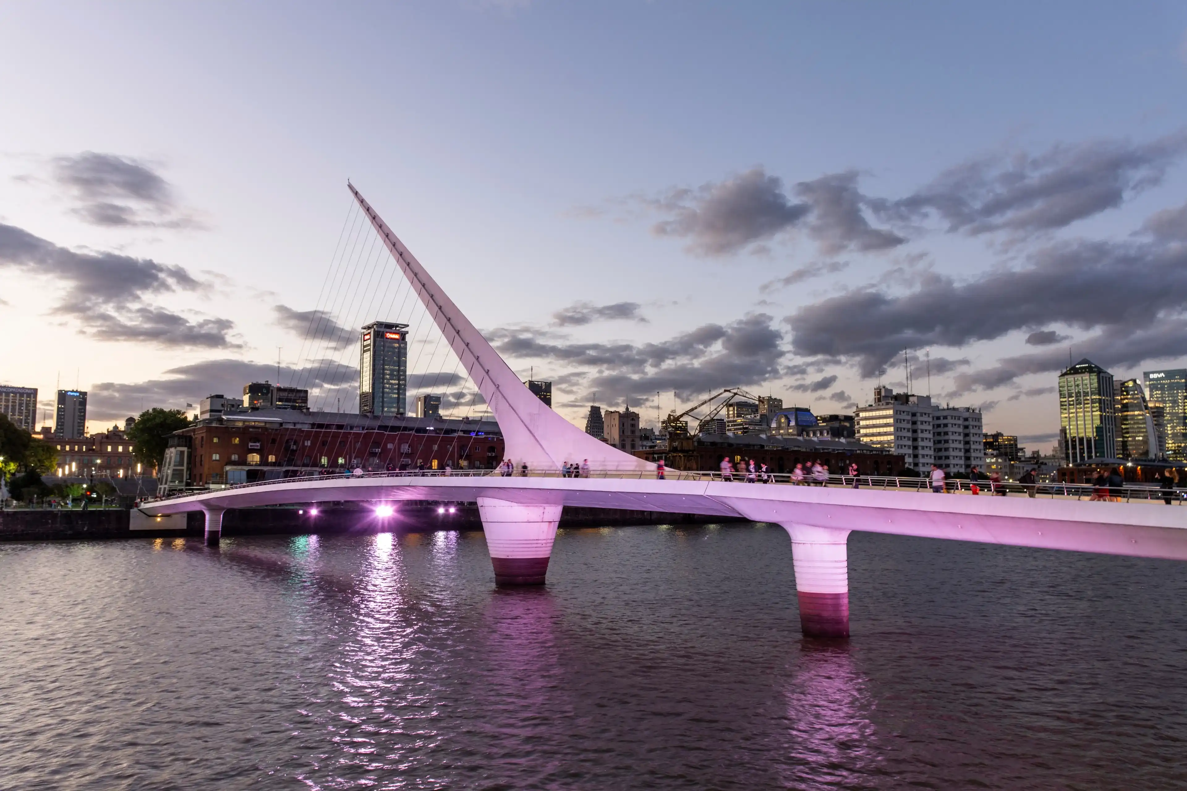 BUENOS AIRES, ARGENTINA - JANUARY 23, 2020: Beautiful view to modern bridge with pink light and buildings BUENOS AIRES, ARGENTINA - JANUARY 23, 2020: Beautiful view to modern bridge with pink light and buildings