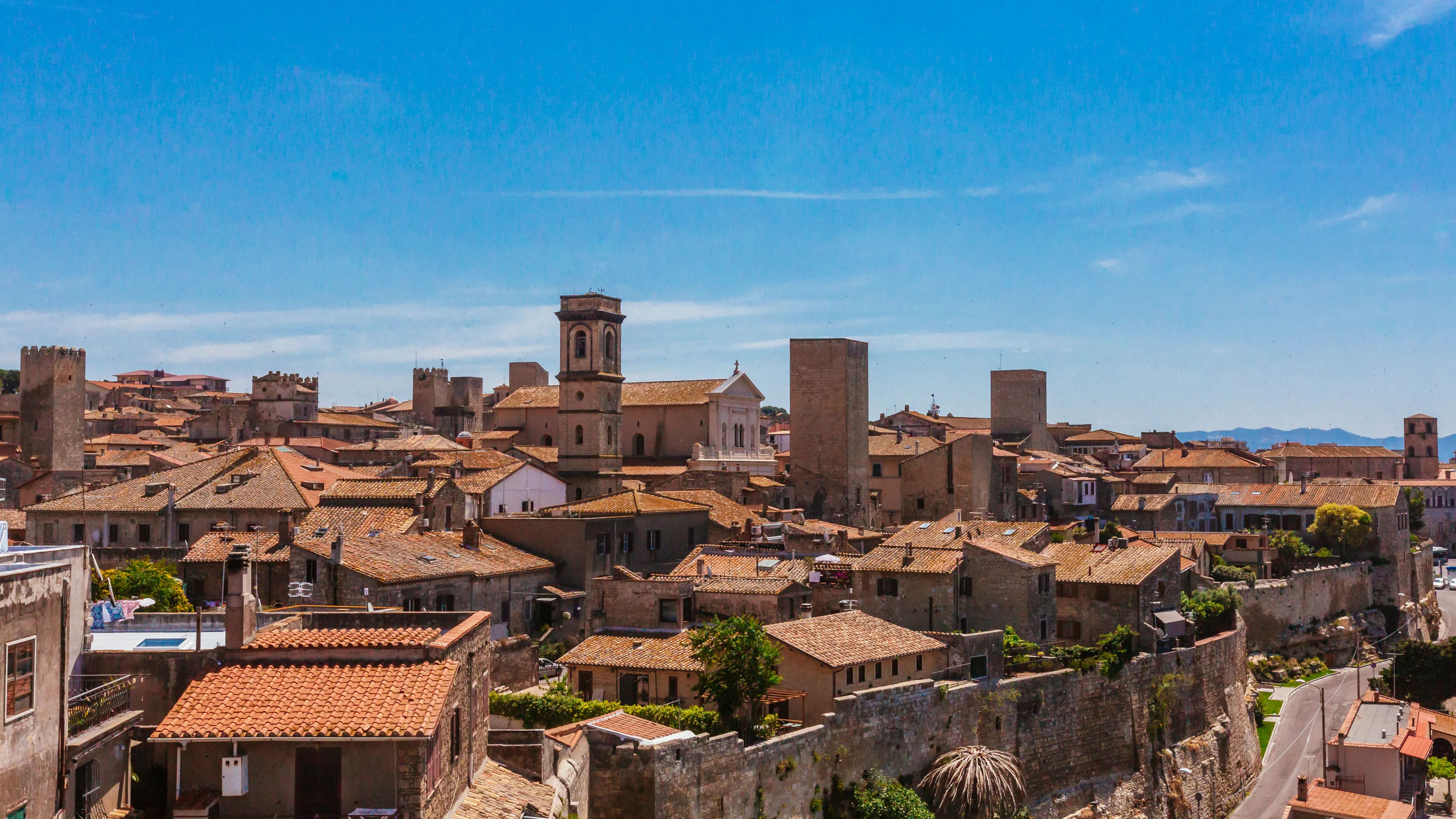 Panoramic view of the architecture and houses of the old town of Tarquinia, Italy under blue sky