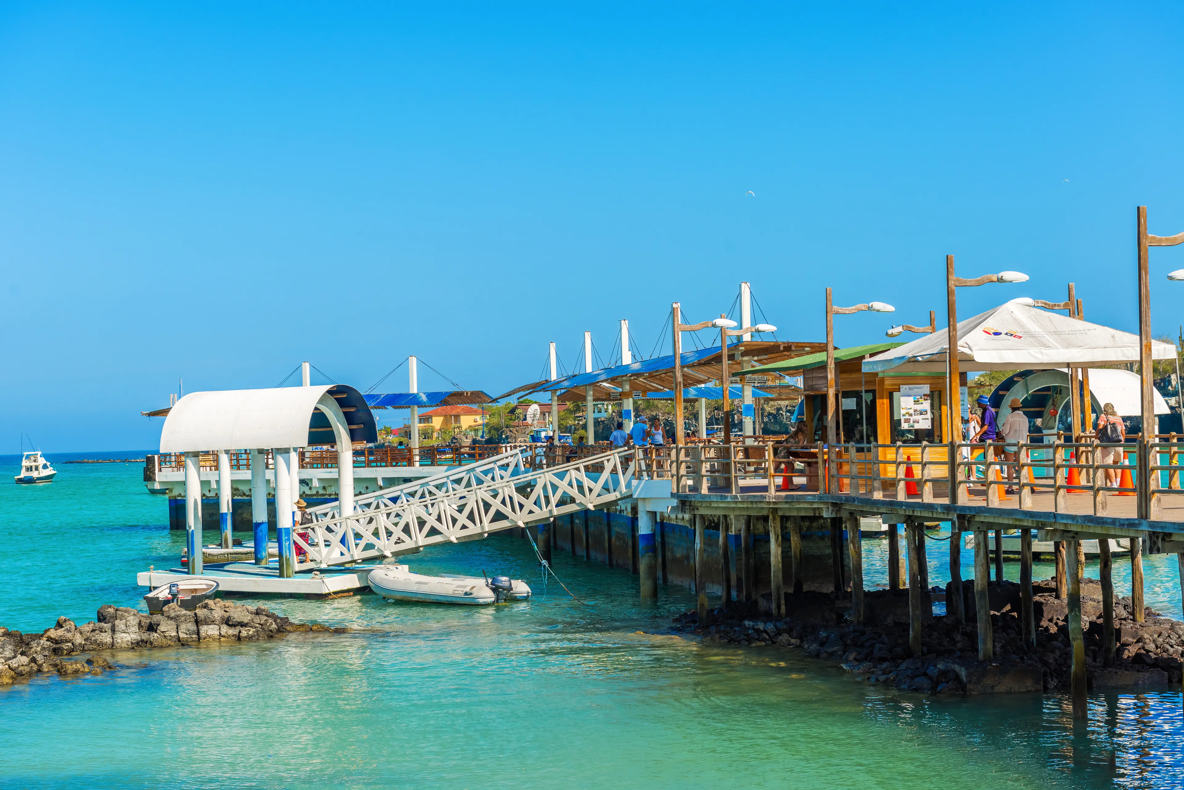 Puerto Ayora, Galapagos, Ecuador - April 1, 2016: People walking and waiting for the boats on the pier in Puerto Ayora in Galapagos on a sunny day.
