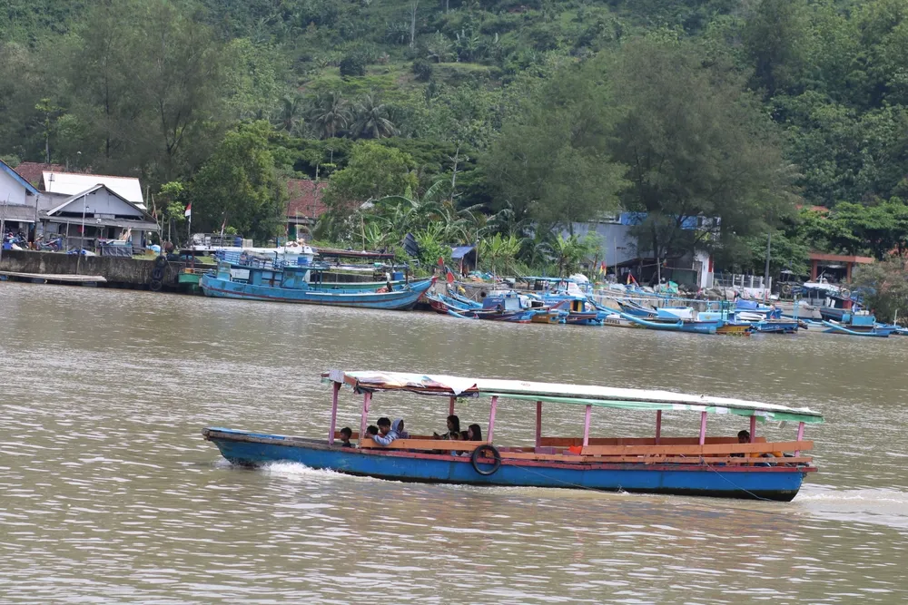 Cilacap, Indonesia - December 26 2024. Traditional boats used by fishermen are sailing along the coast