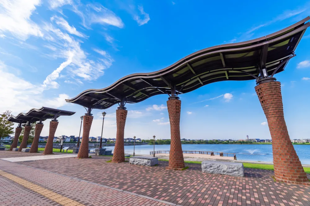 KOSHIGAYA, SAITAMA / JAPAN - SEPTEMBER 27 2019 : Scenery of “Koshigaya Lake Town”. There is a park with a spacious lawn and a large pond. It is a new town that has been re-developed.