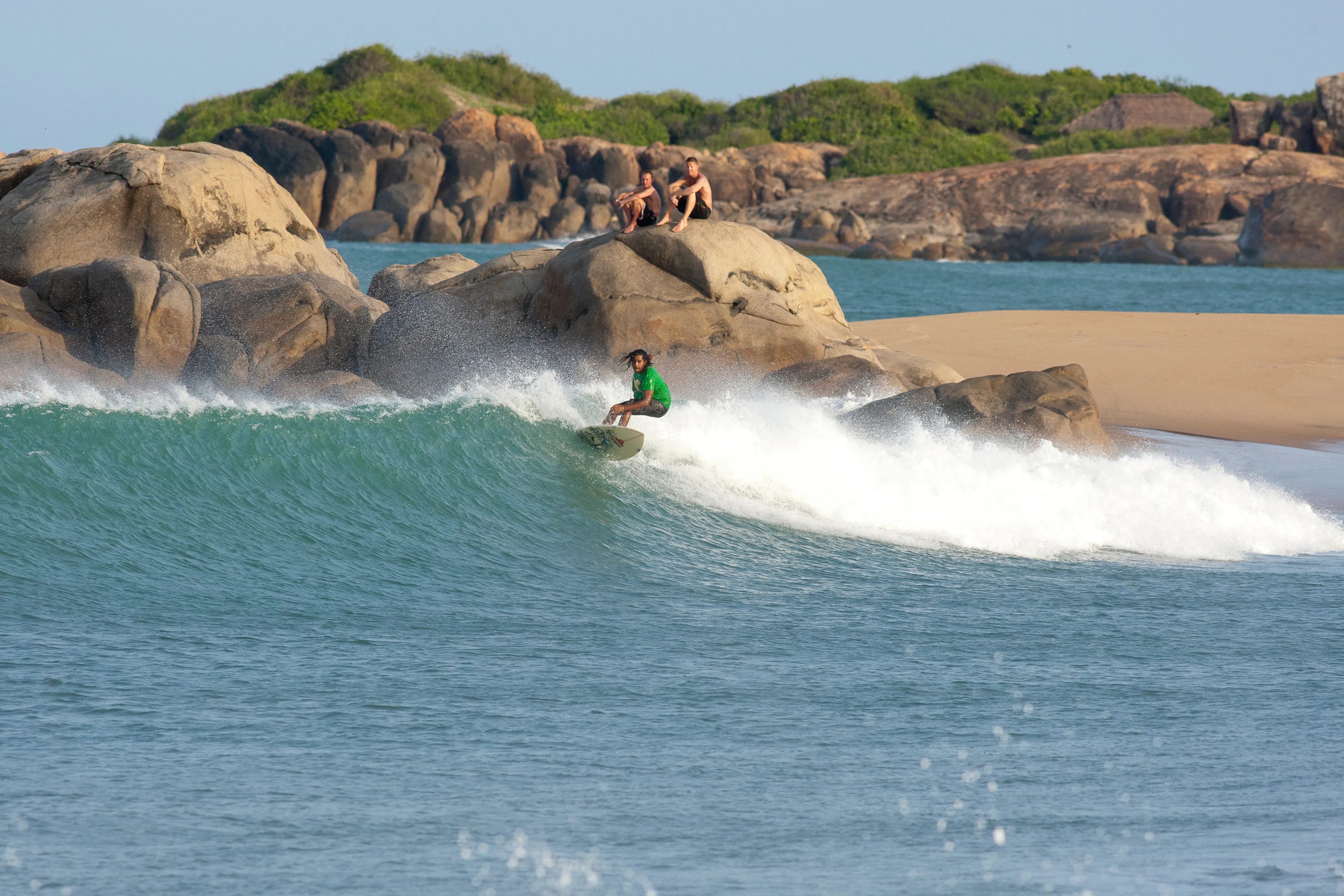 Arugam Bay, Eastern Province / Sri Lanka - May 24 / 2013: A local surfer riding waves at the popular surf break of Whiskey Point, Pottuvil, Sri Lanka