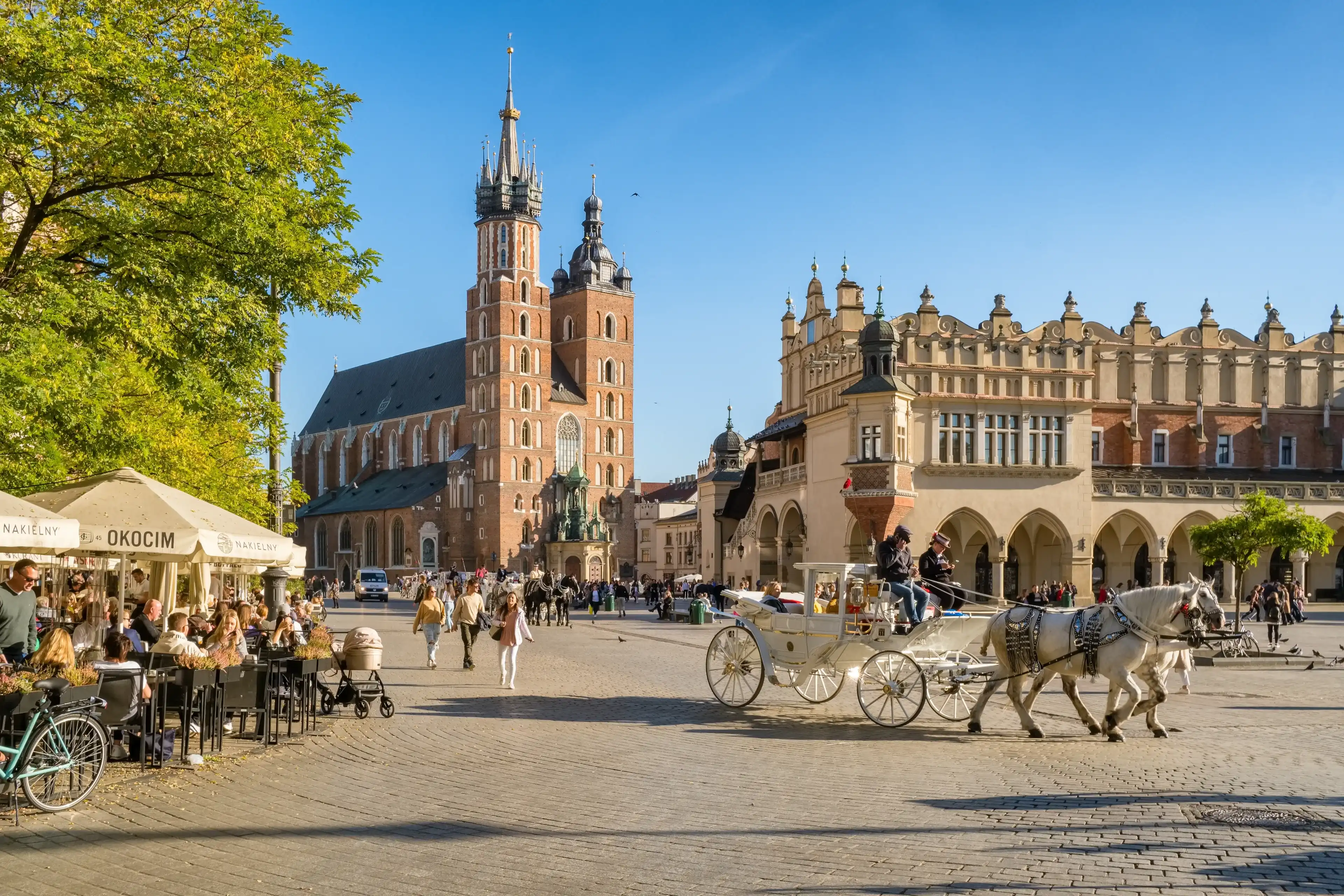 Krakow, Poland - October 27, 2022: Krakow cloth hall and Saint Mary's Basilica on the main market square at sunny day in Cracow, Poland. Krakow, Poland - October 27, 2022: Krakow cloth hall and Saint Mary's Basilica on the main market square at sunny day in Cracow, Poland.