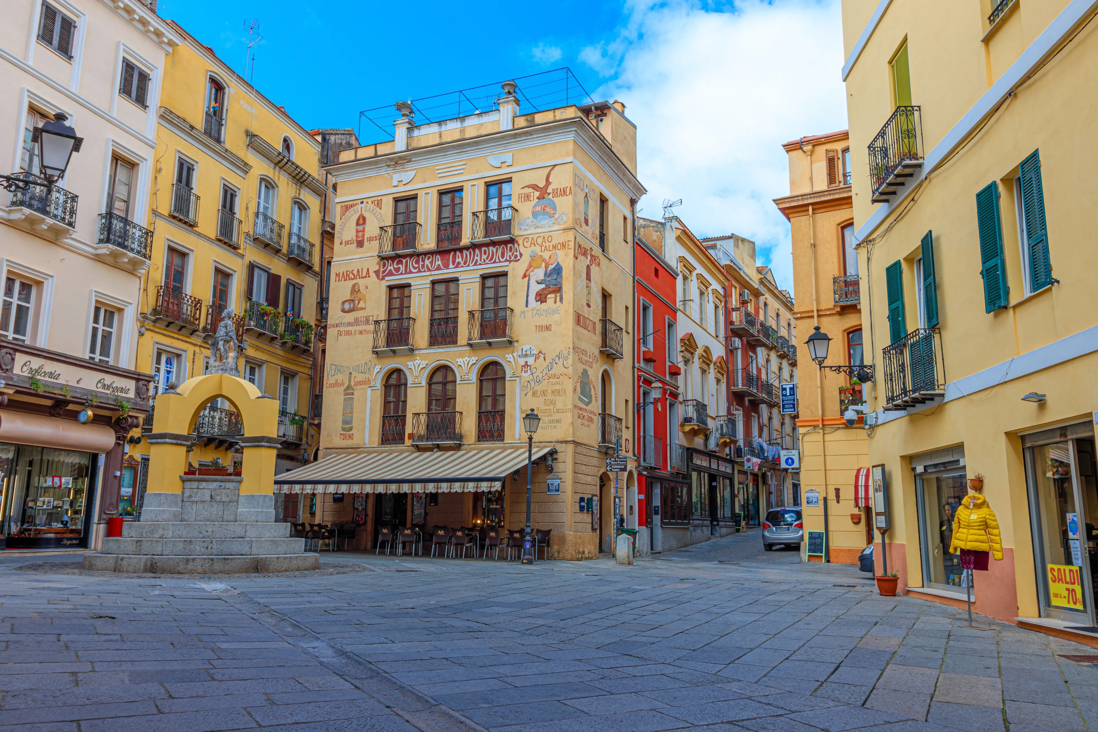 Iglesias, Italy - 03 13 2024: Facade of pastry shop "Pasticceria Lamarmora" and Maimoni fountain