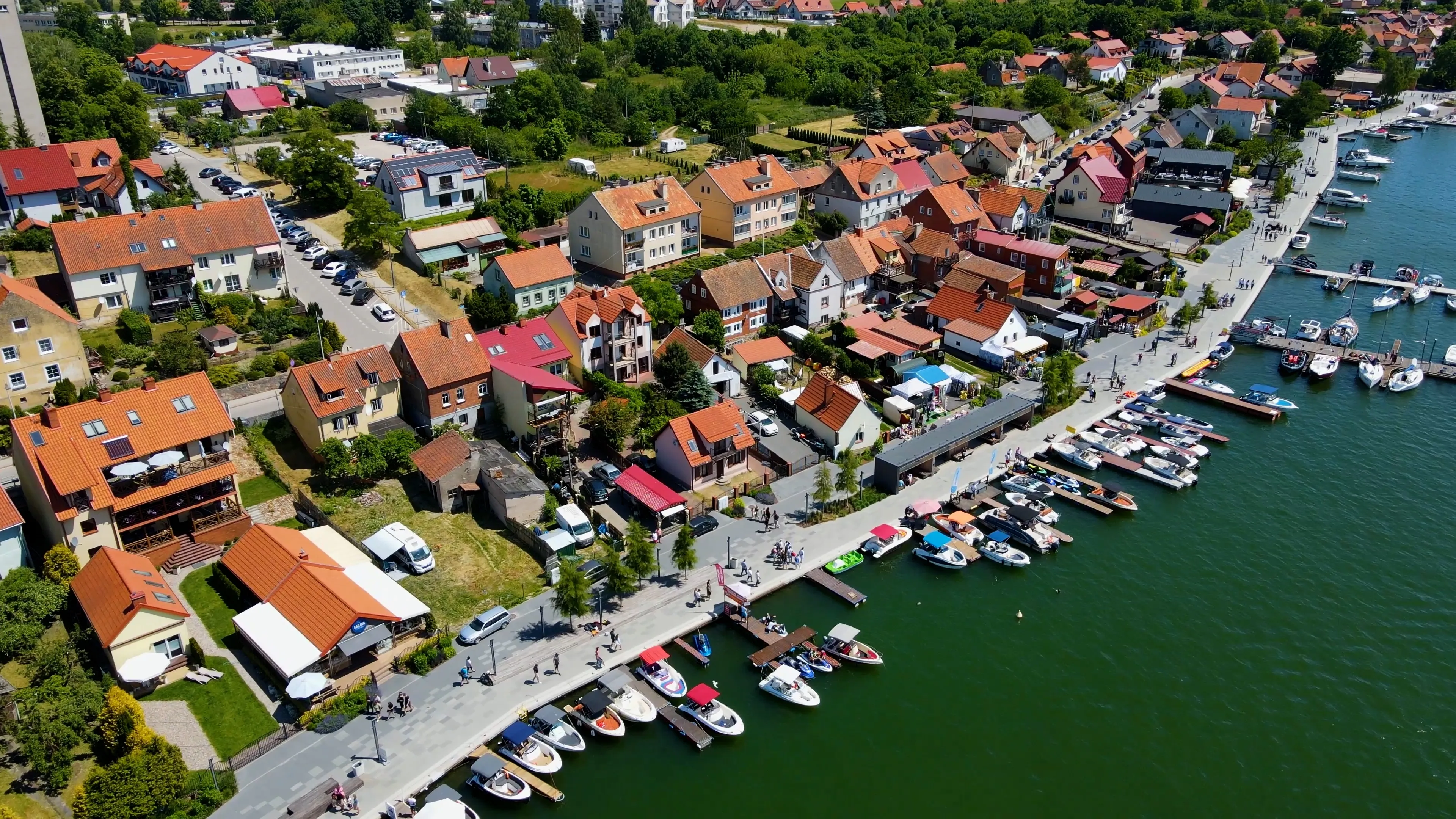 Panoramic aerial photo from drone to Mikolajki townscape - capital of Masurian region on the shore of the holiday resort beautiful summer afternoon. Mikolajki, Mikołajki, Poland, Europe.