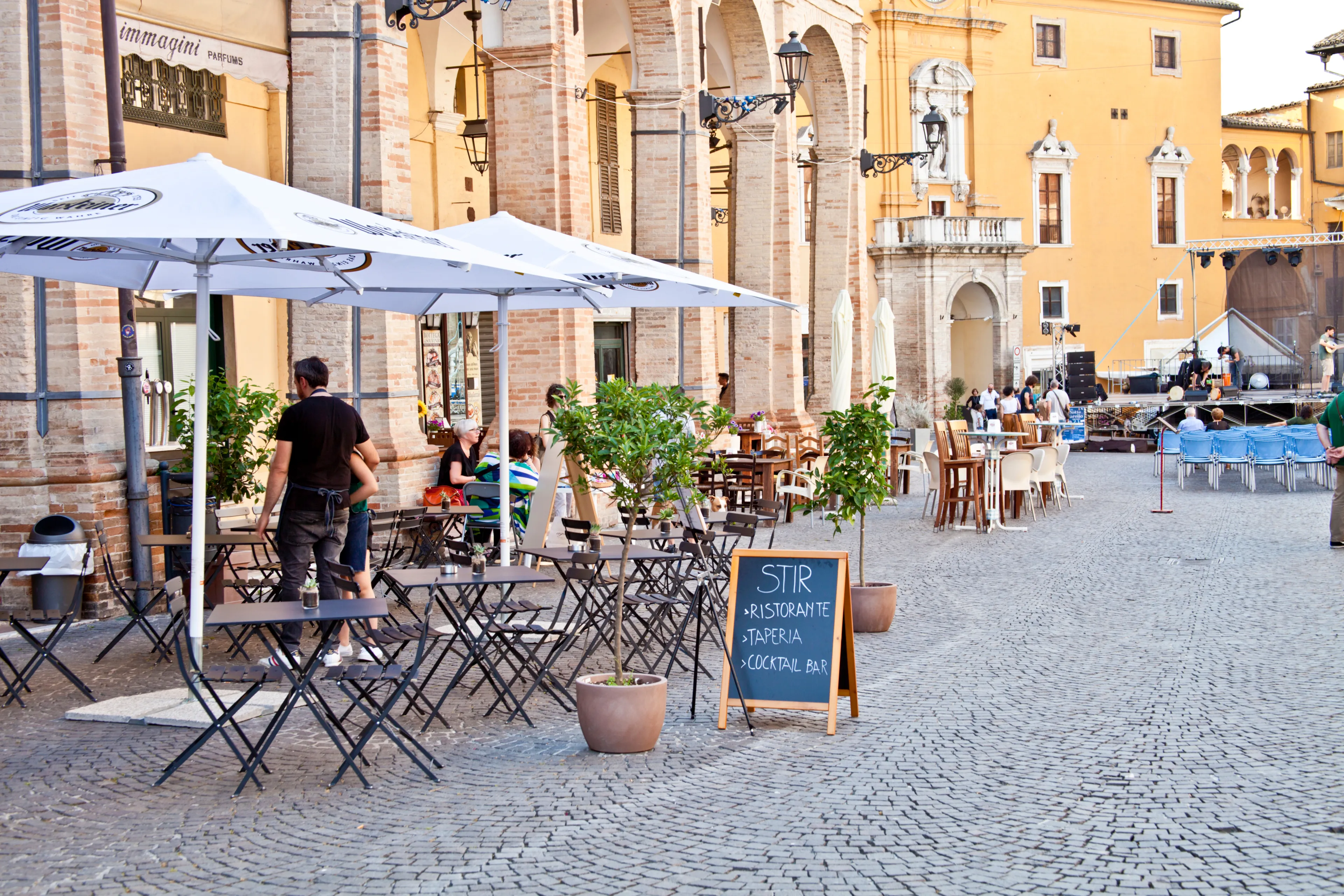 Fermo, Italy - June 23, 2019: People enjoying summer day and food at outdoor restaurant and resting, Piazza del Popolo, Fermo, Italy