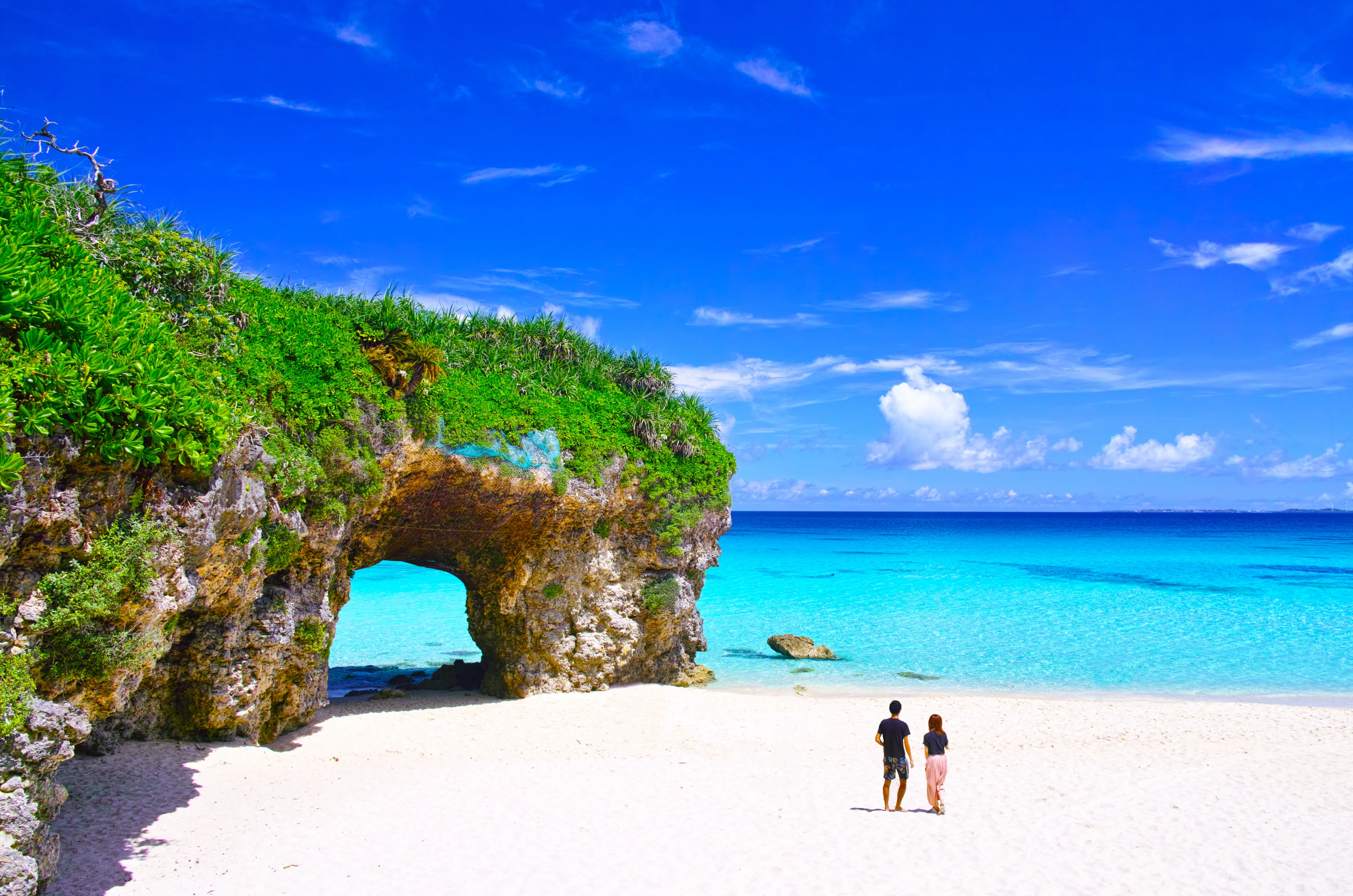 Miyakojima in summer. A couple watching the ocean at Sunayama beach