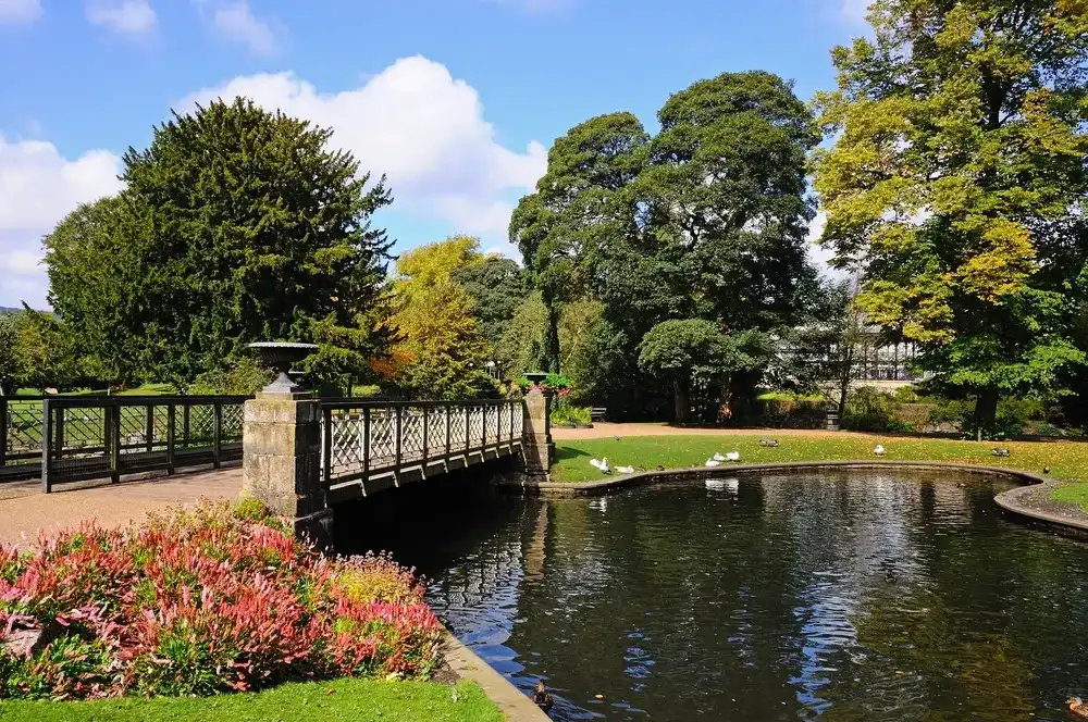 BUXTON, UNITED KINGDOM - SEPTEMBER 7, 2014 - Footbridge across the lake in the Pavilion Gardens, Buxton, Derbyshire, England, UK, Western Europe, September 7, 2014. BUXTON, UNITED KINGDOM - SEPTEMBER 7, 2014 - Footbridge across the lake in the Pavilion Gardens, Buxton, Derbyshire, England, UK, Western Europe, September 7, 2014.