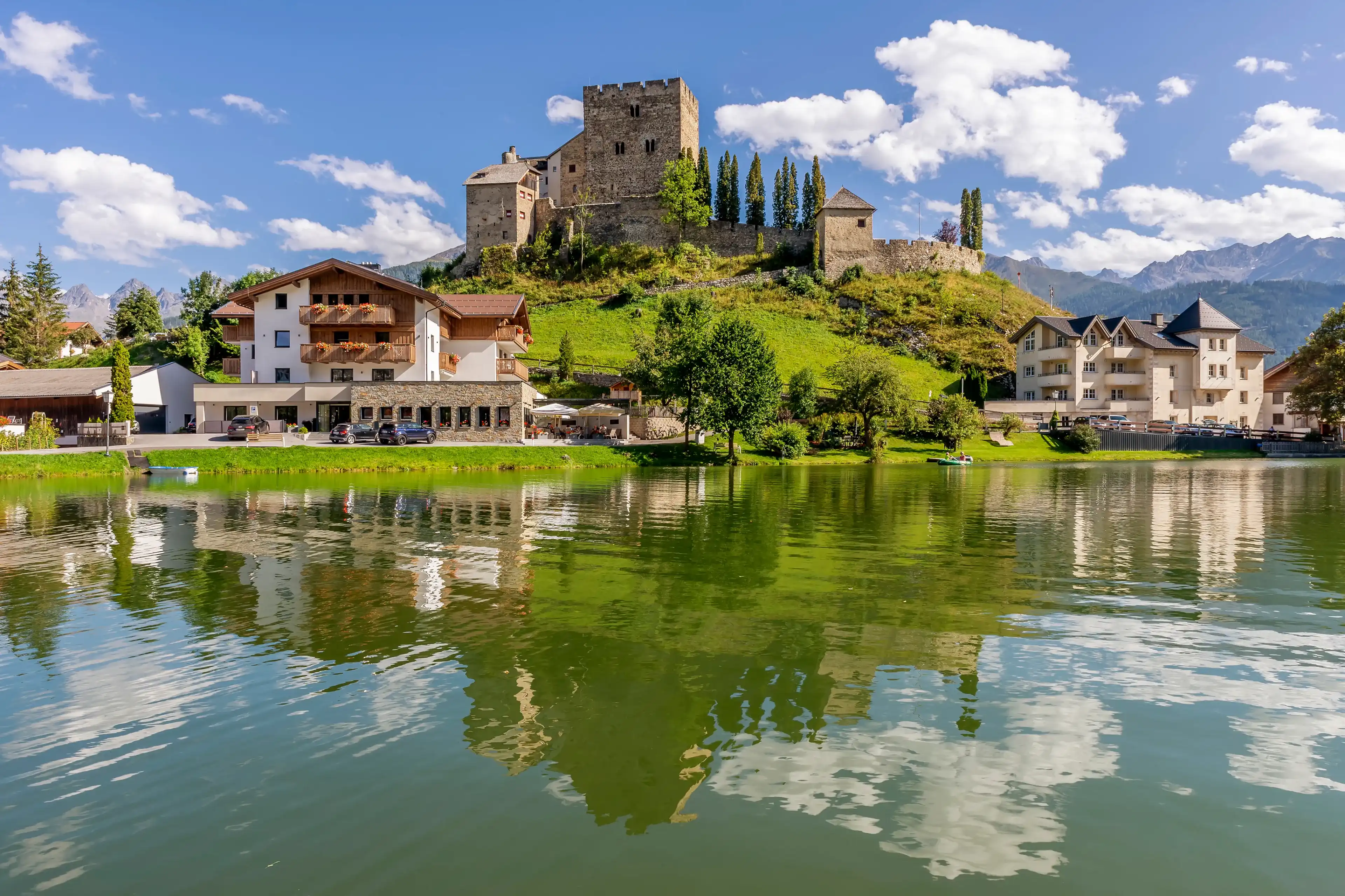 Laudegg Castle is reflected in the lake below on a beautiful sunny day, Ladis, Serfaus, Tyrol, Austria Laudegg Castle is reflected in the lake below on a beautiful sunny day, Ladis, Serfaus, Tyrol, Austria