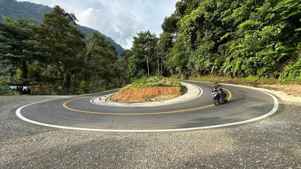 Bengkulu, Indonesia, December 14, 2024 : Motorcyclist passing a sharp bend in the hill, 4k, landscape, portrait Bengkulu, Indonesia, December 14, 2024 : Motorcyclist passing a sharp bend in the hill, 4k, landscape, portrait