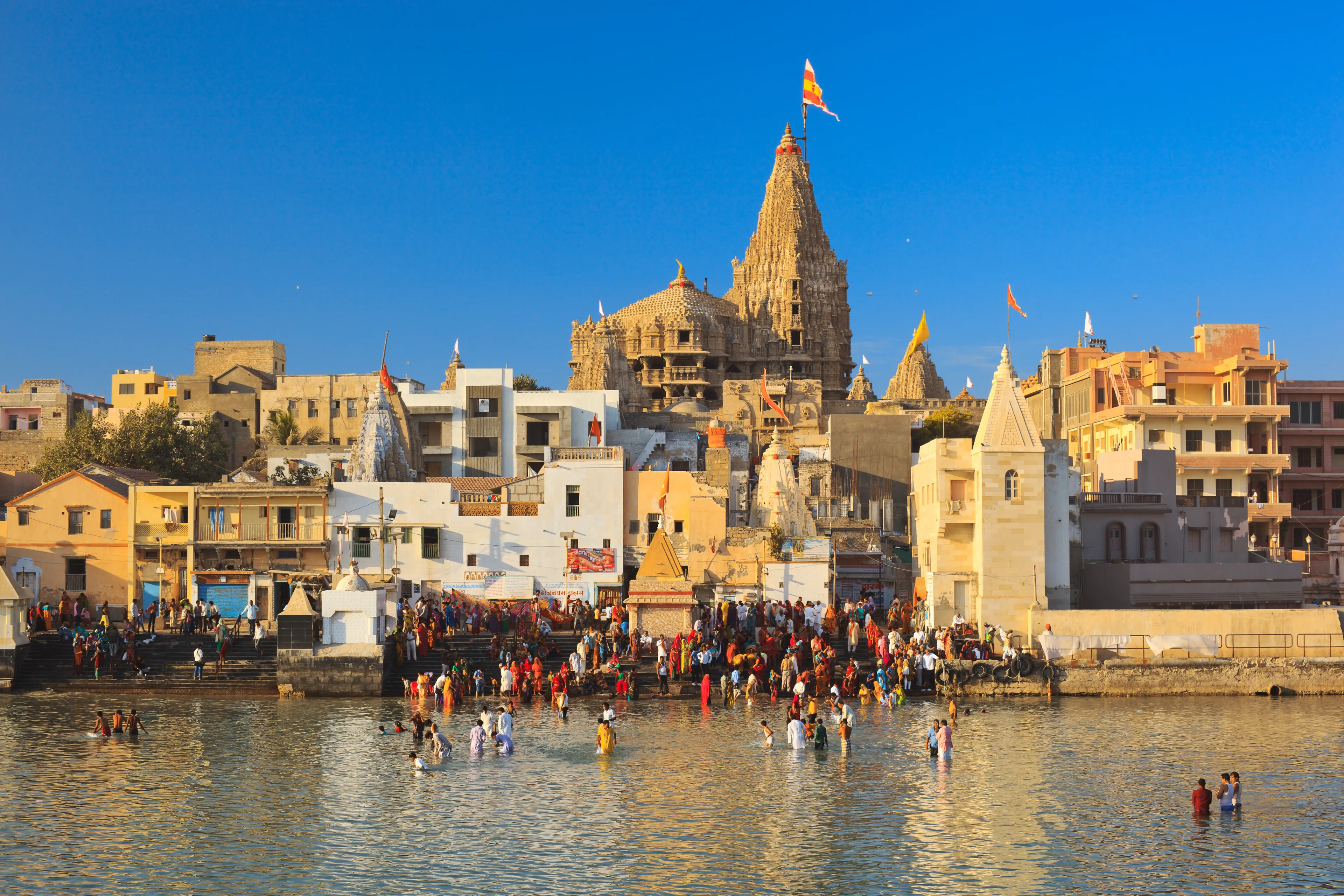 DWARKA, INDIA - JANUARY 3: Hindu pilgrims take a holy bath in the river Gomti. View of Gomti Ghat and Krishna temple Shree Dwarkadhish on January 3, 2016 in Dwarka