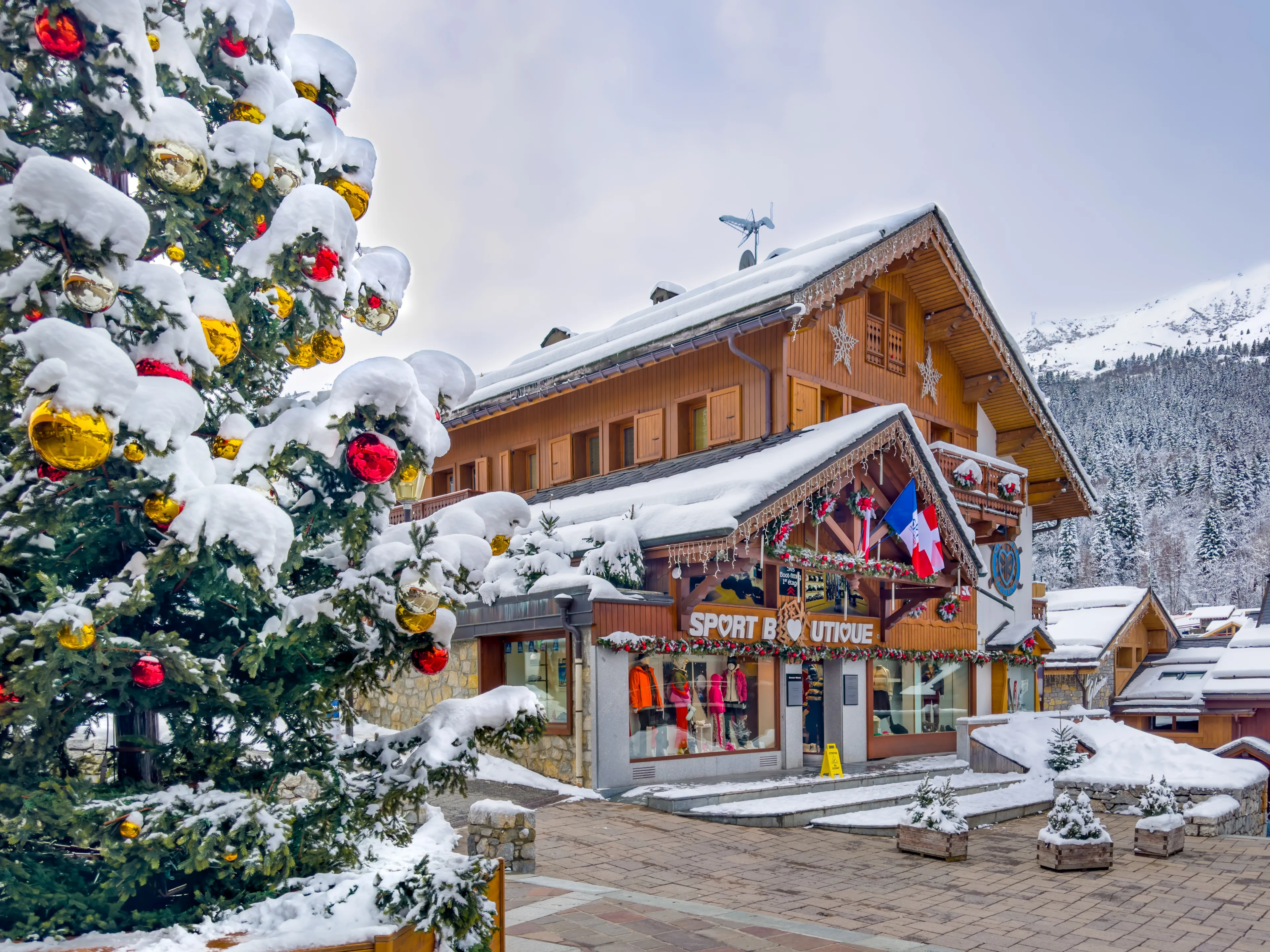COURCHEVEL - MERIBEL, FRANCE - JANUARY 15, 2023 : Christmas tree and wood chalets in Meribel, France.