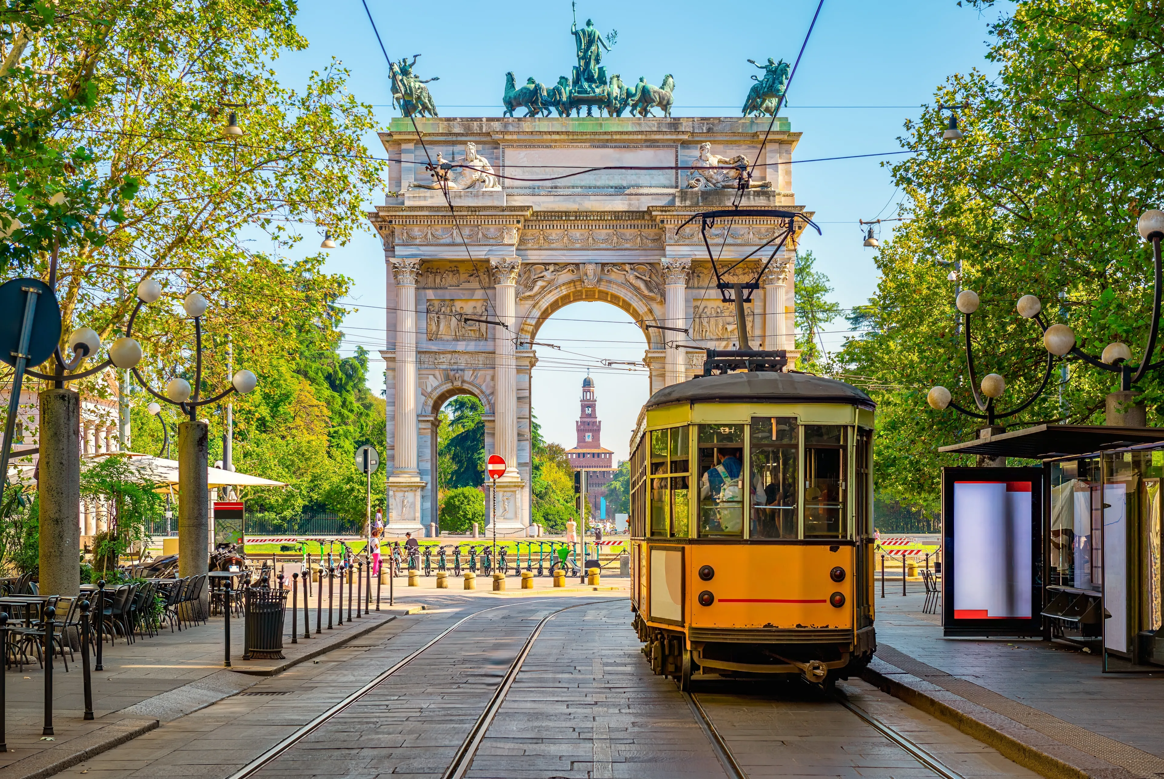 View of the Peace Arch with yellow tram in Milan, Italy