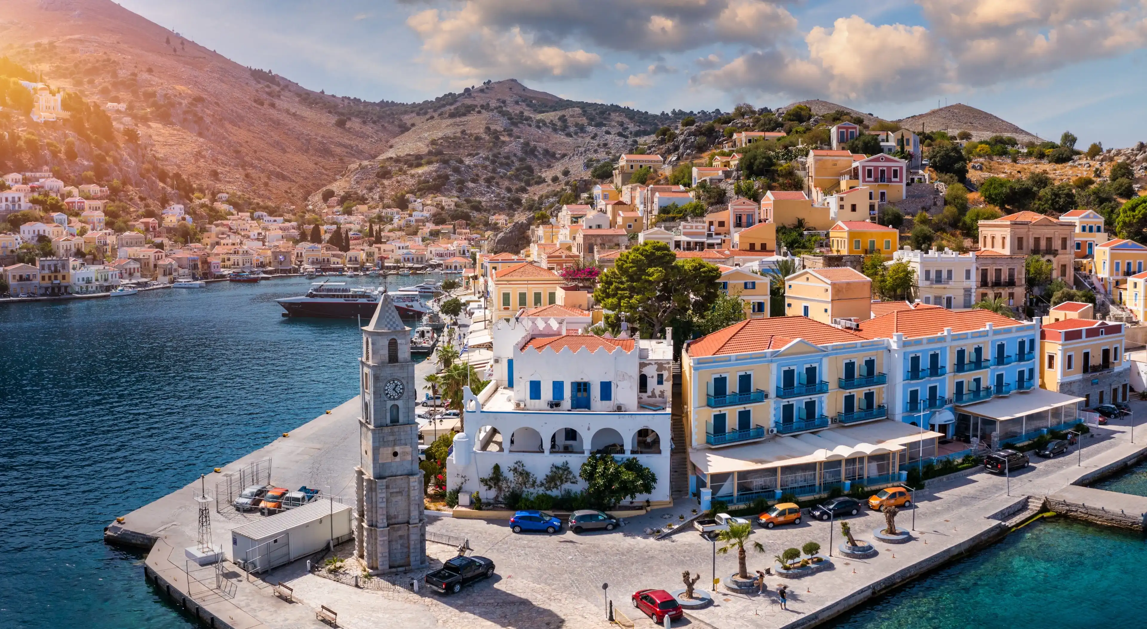 Aerial view of the beautiful greek island of Symi (Simi) with colourful houses and small boats. Greece, Symi island, view of the town of Symi (near Rhodes), Dodecanese. Aerial view of the beautiful greek island of Symi (Simi) with colourful houses and small boats. Greece, Symi island, view of the town of Symi (near Rhodes), Dodecanese.
