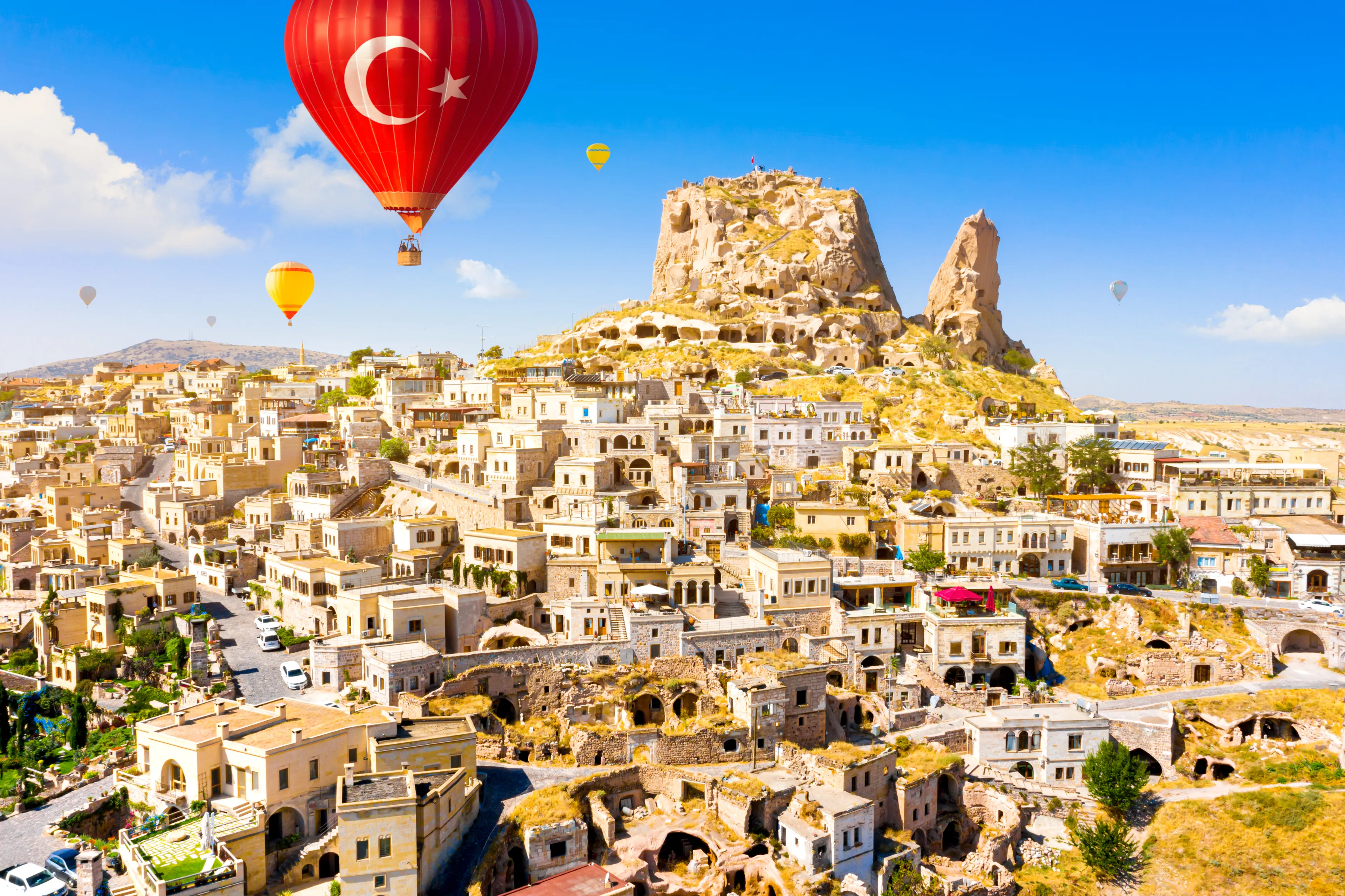 Hot air balloons flying over Uchisar Castle. Cappadocia. Nevsehir Province. Turkey