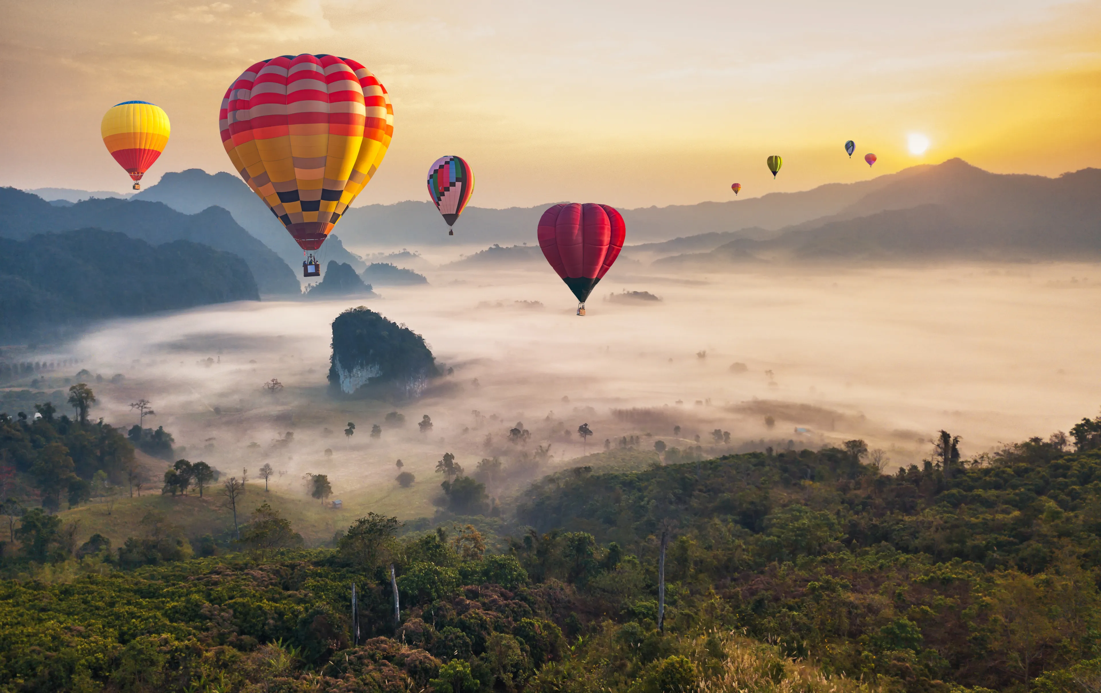Colorful hot air balloons flying over mountain at Phu Langka national park, Phayao province in Thailand.