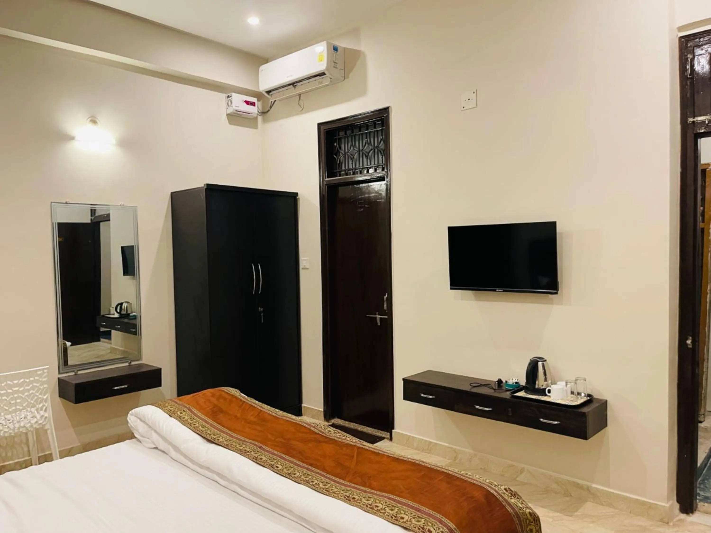 Bed, TV/Entertainment Center in Goroomgo Assi River Guest House Varanasi