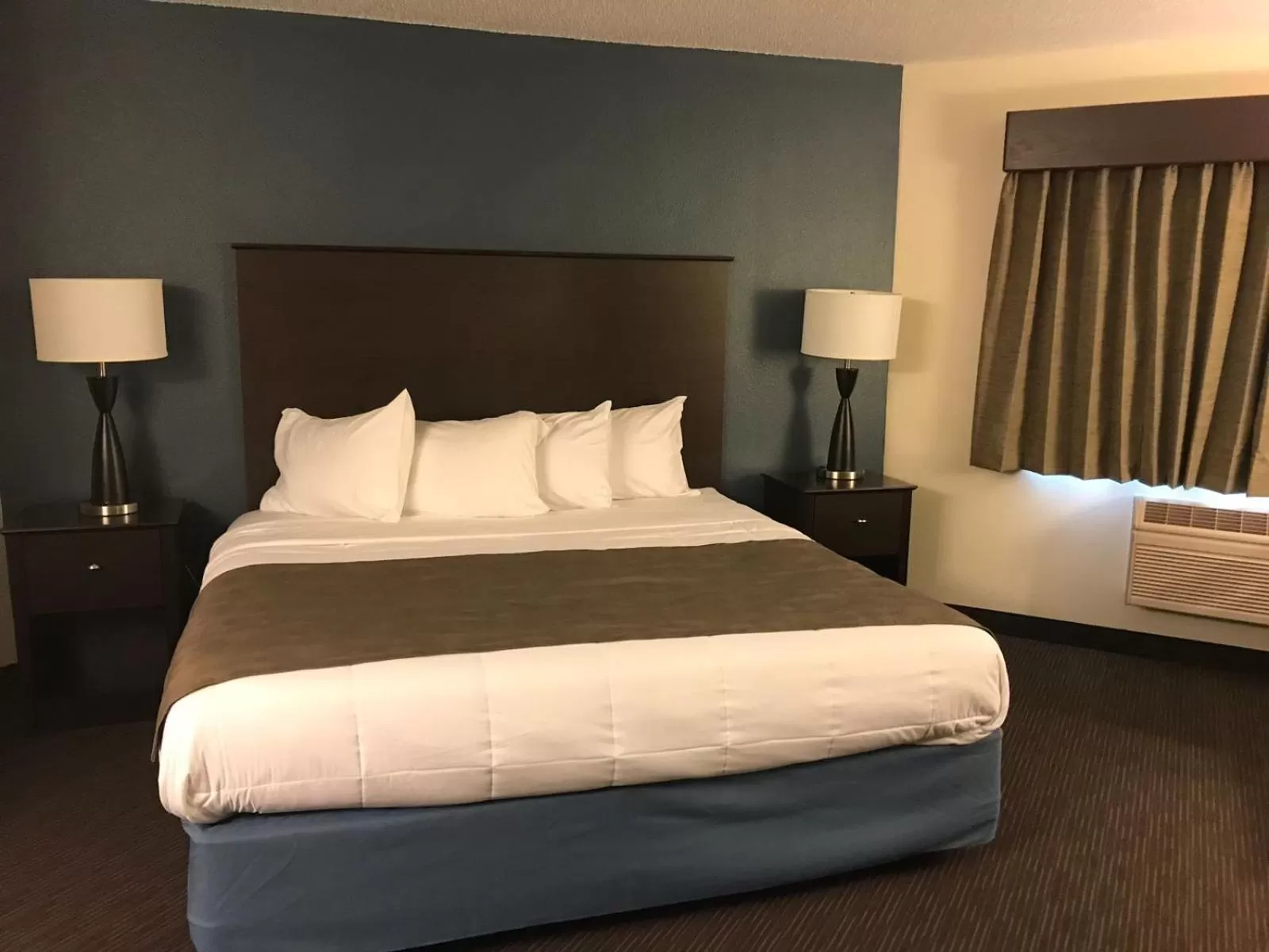Bed in AmericInn by Wyndham Hotel and Suites Long Lake