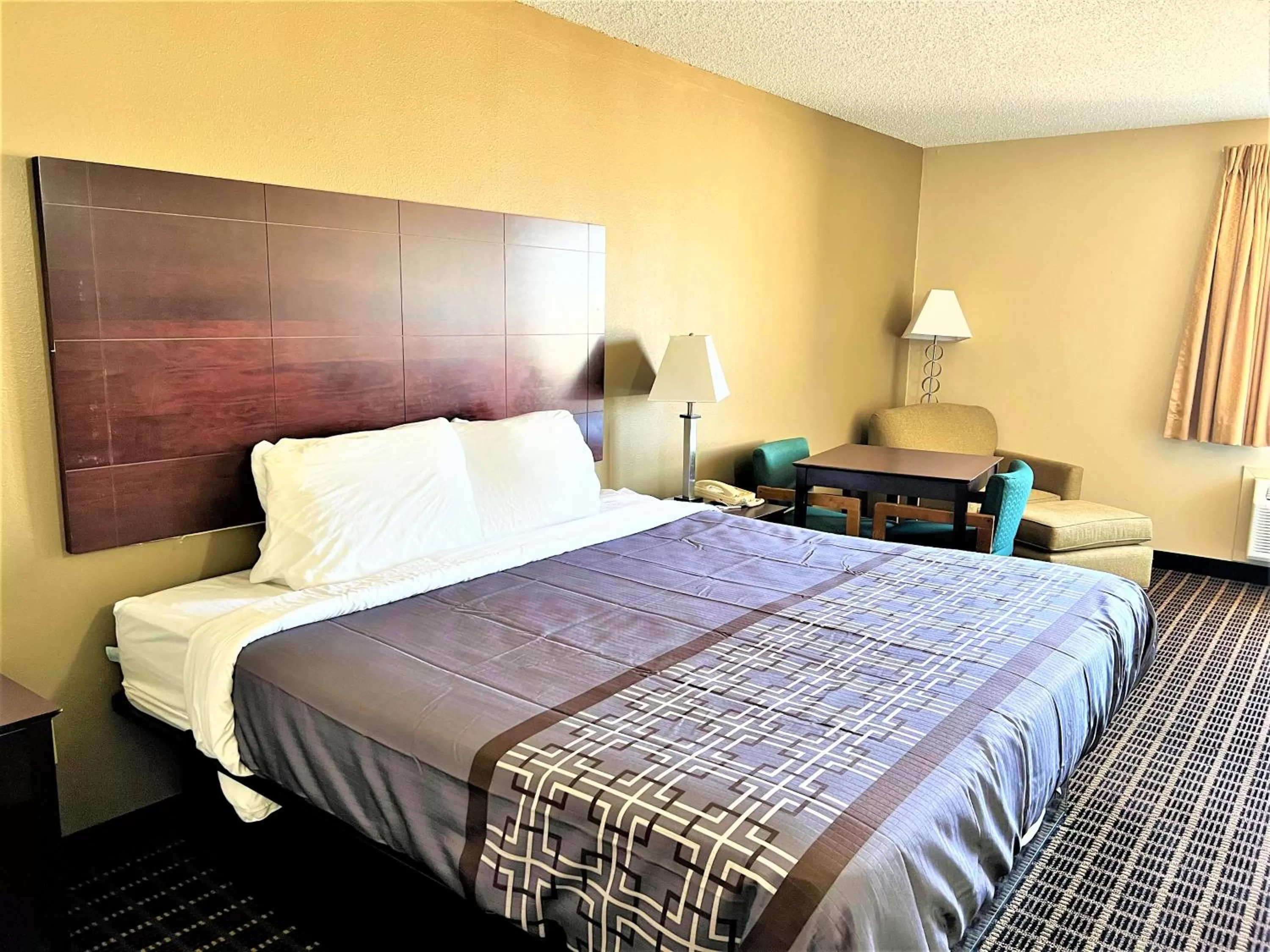 Bed in Designer Inn and Suites