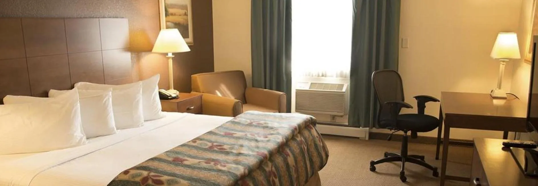 Photo of the whole room, Bed in Magnuson Grand Pioneer Inn and Suites