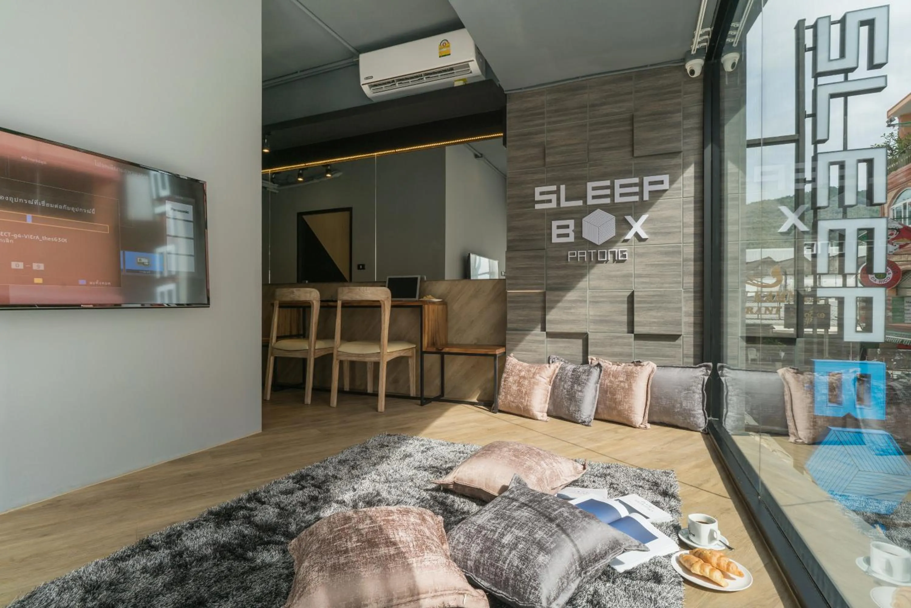 Communal lounge/ TV room in Sleep Box Patong Hostel