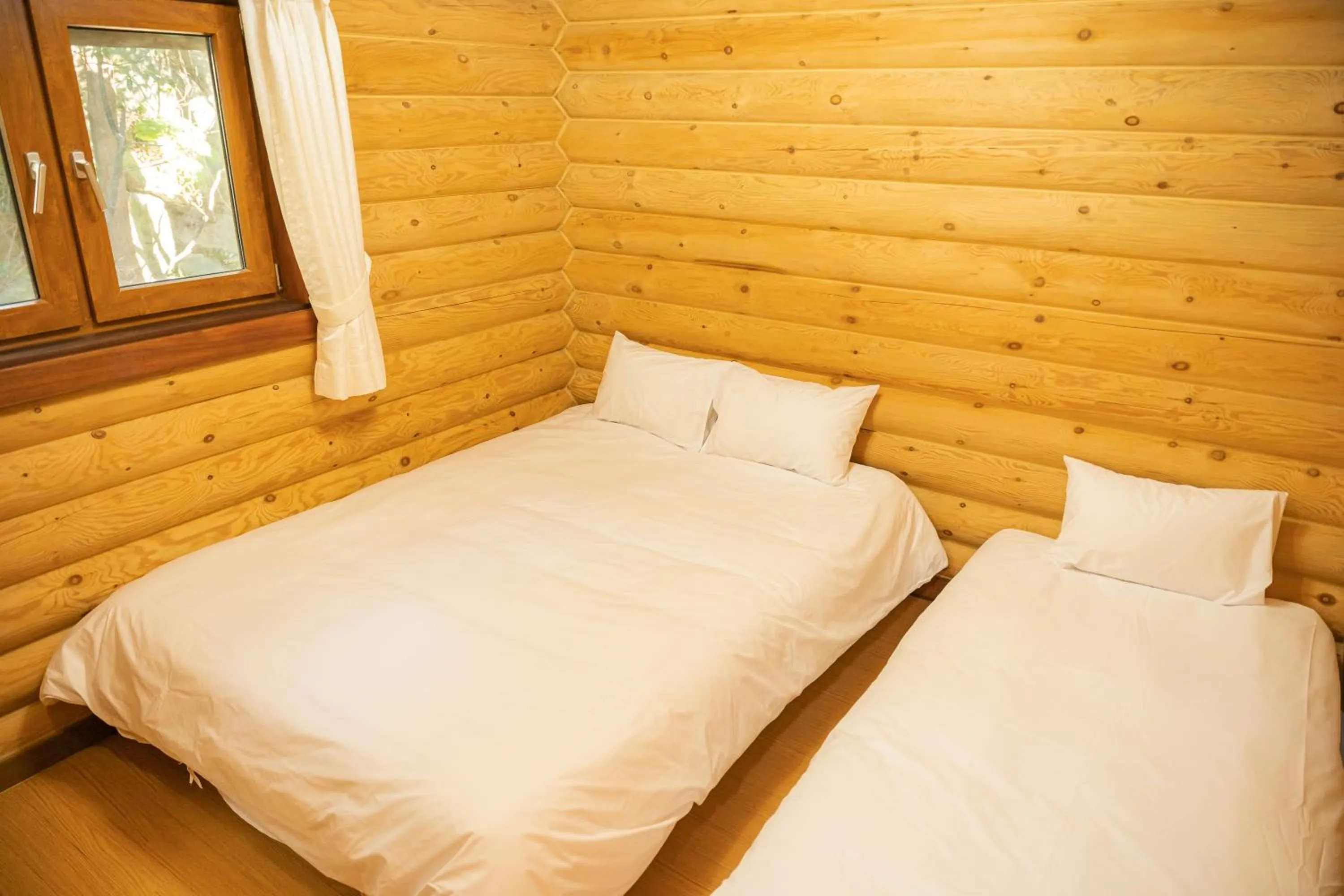 Bed in Jungmun Log Pension & Resort