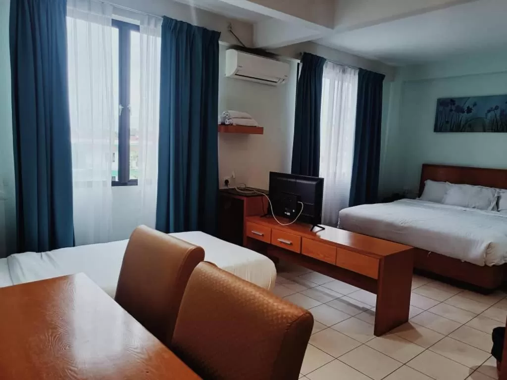 Communal lounge/ TV room, Bed in Fratini's Hotel Labuan