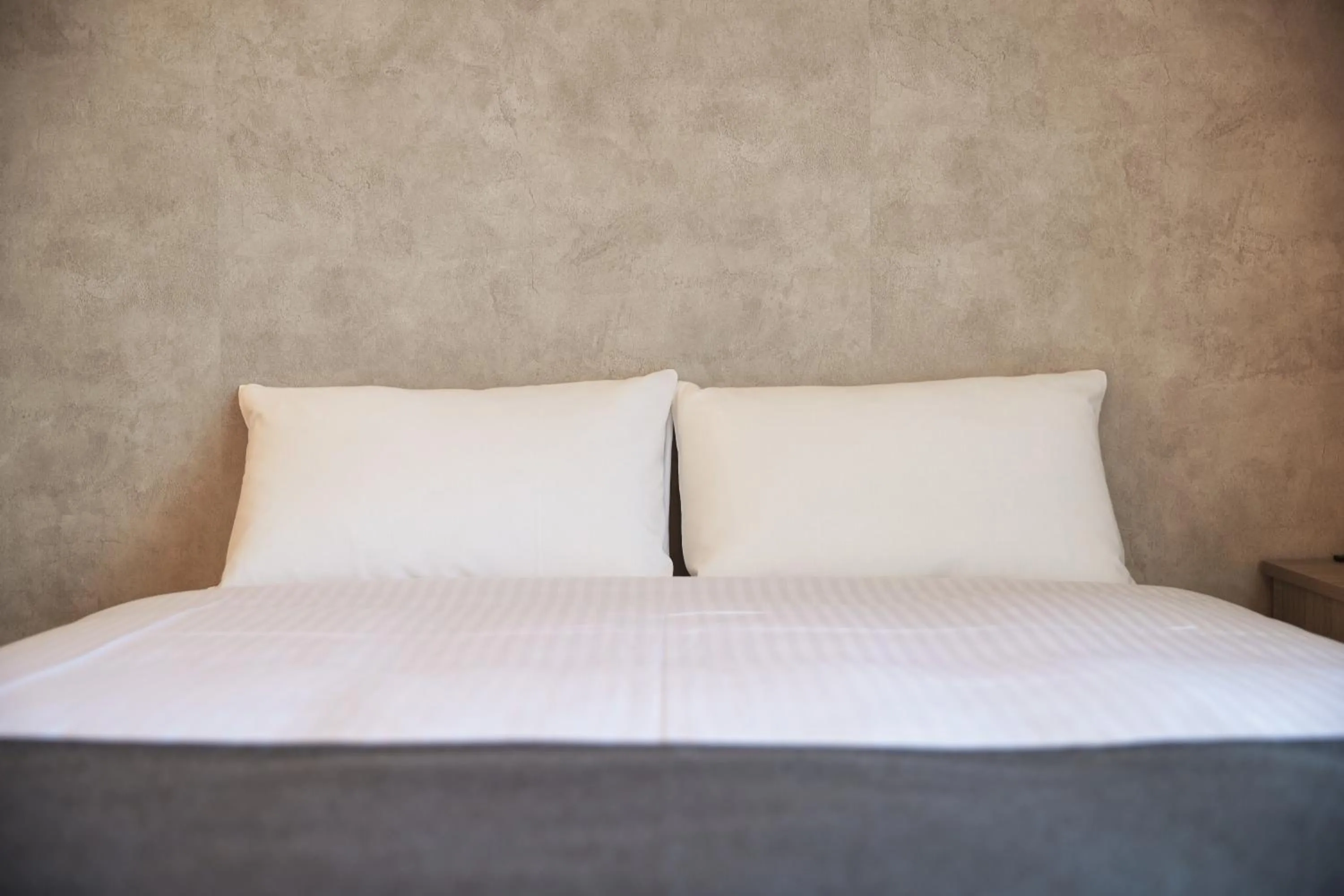 Bed in New Normal Hotel in NAMINOUE ニューノーマルホテルイン波の上