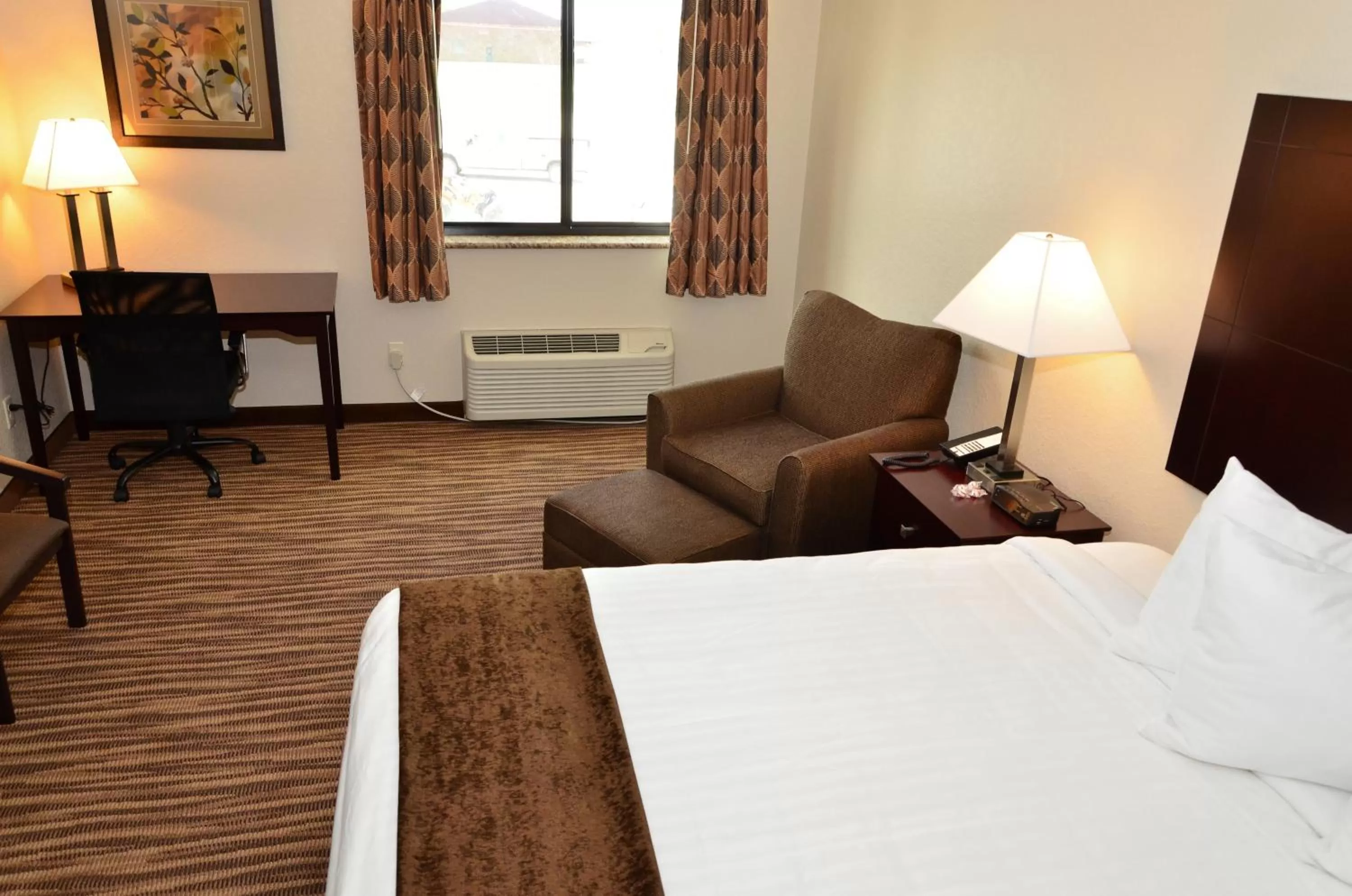 Seating area, Bed in Cobblestone Inn & Suites - Clarion