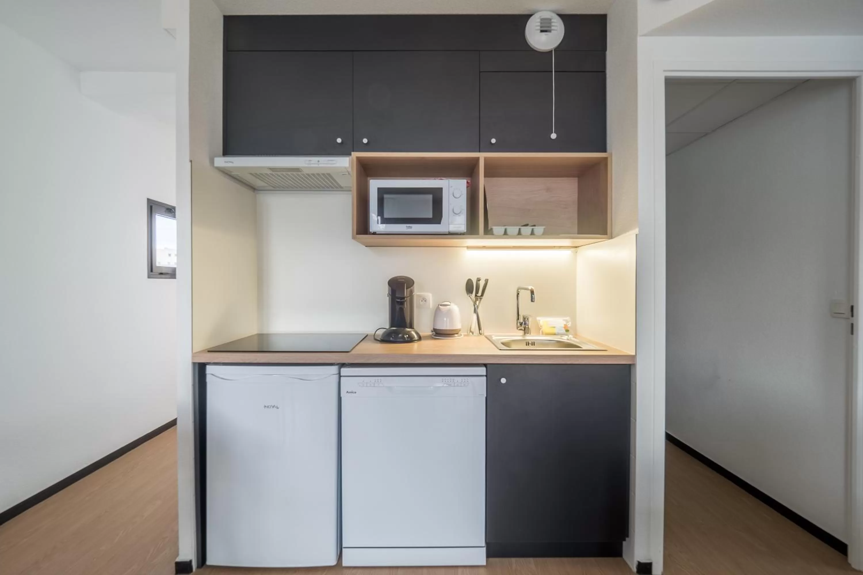 Kitchen or kitchenette in Apparthotel Le Hüb Grenoble