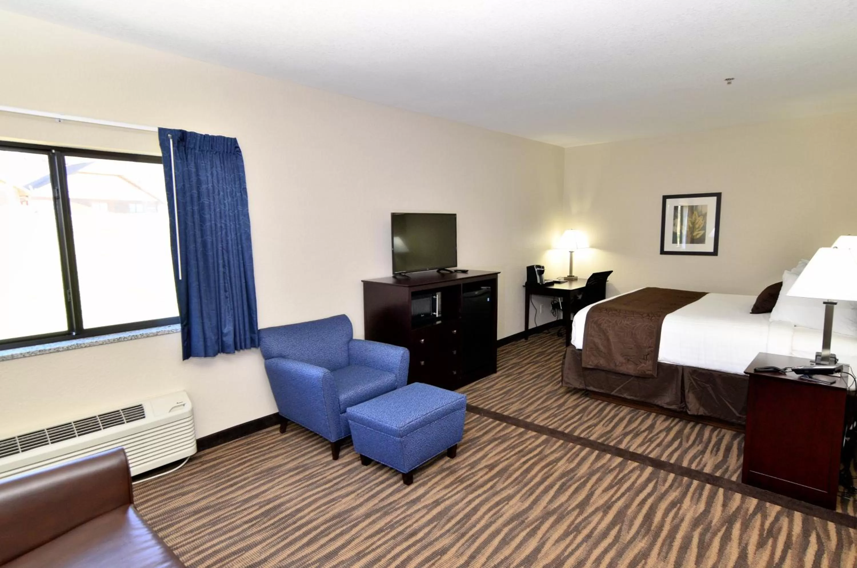 Seating area, Bed in Cobblestone Inn & Suites - Manning