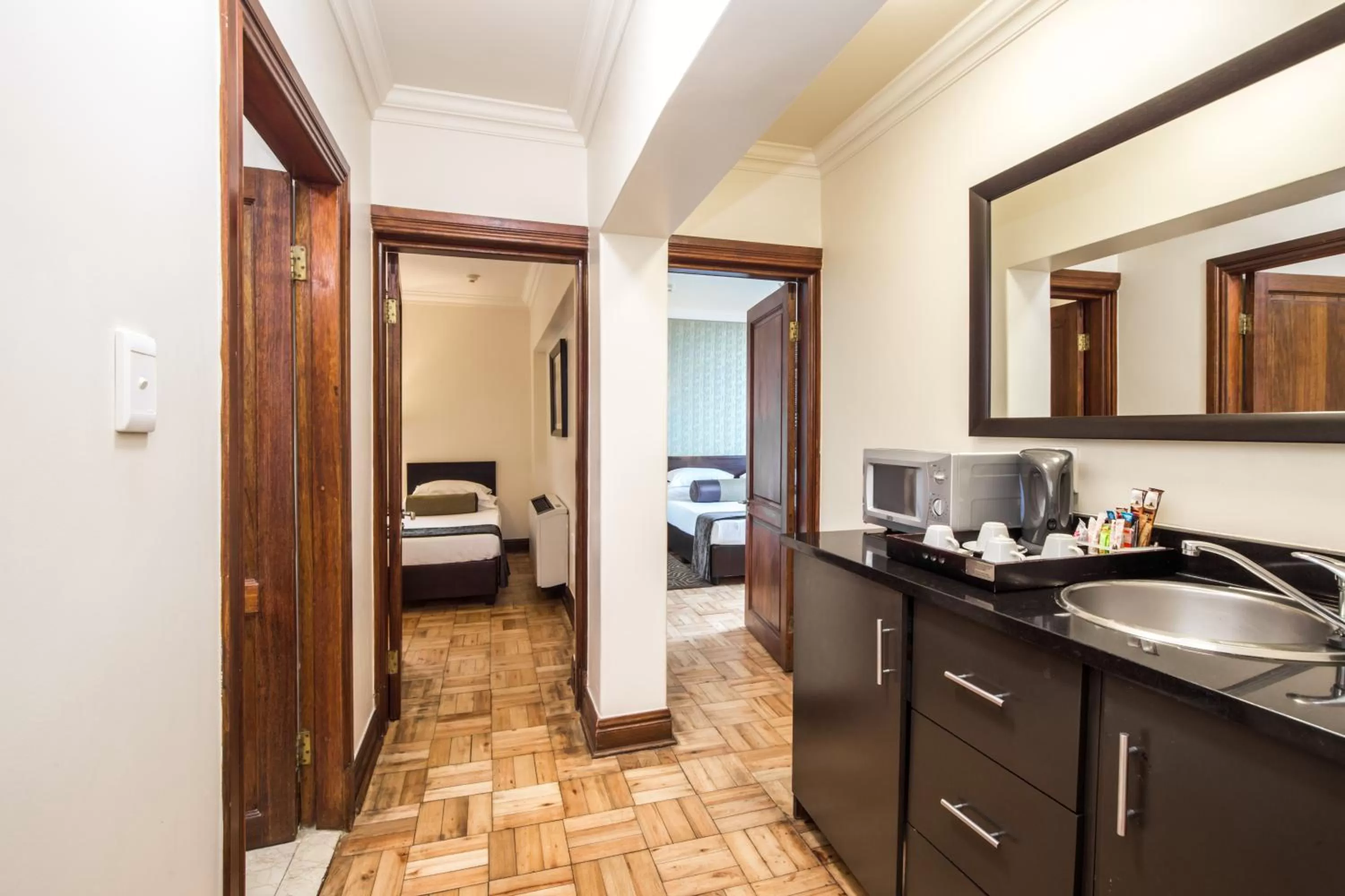 Kitchen or kitchenette, Bed in Belaire Suites Hotel