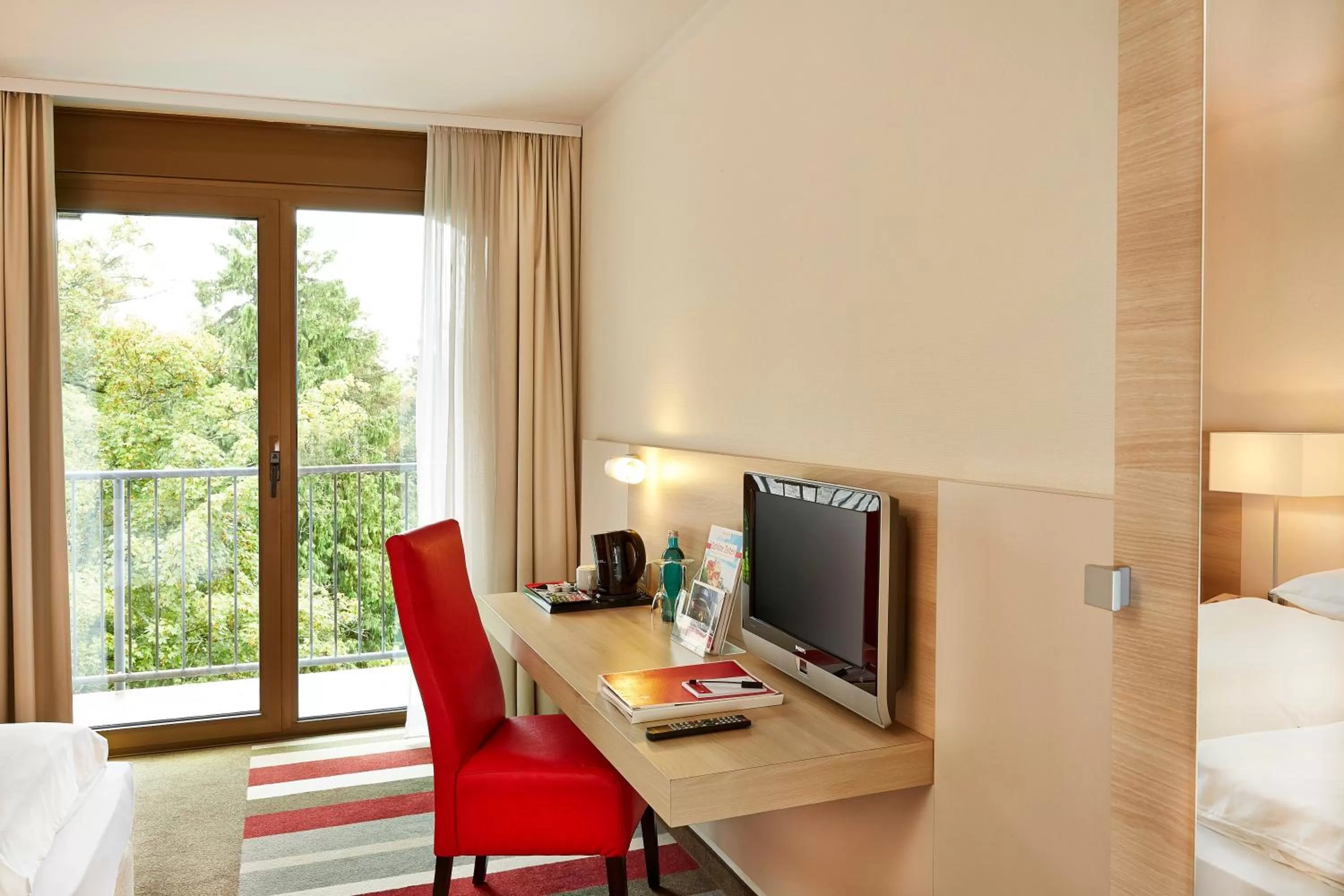 Seating area, Bed in H+ Hotel Bad Soden