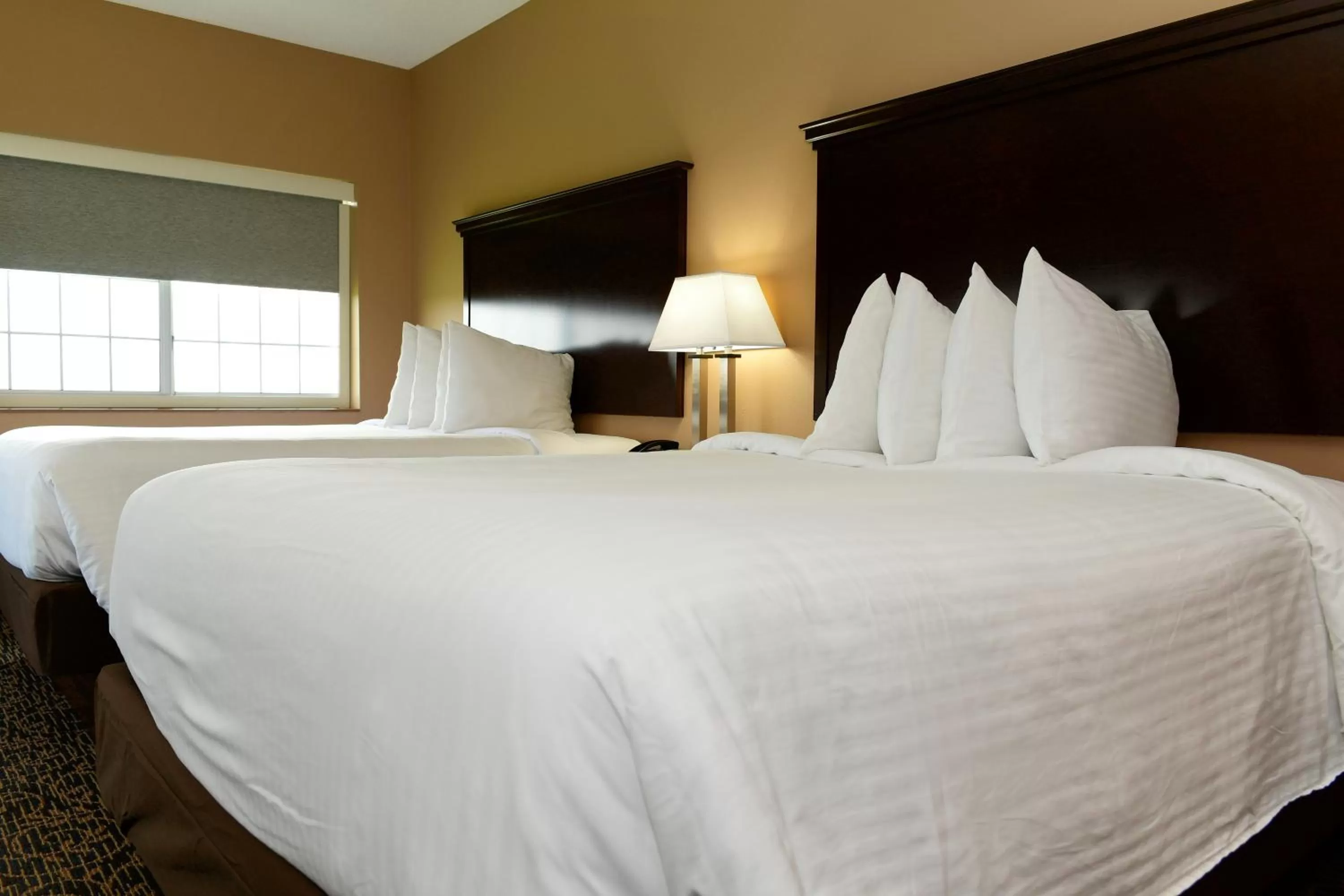 Bed in Cobblestone Inn & Suites - Denison | Majestic Hills