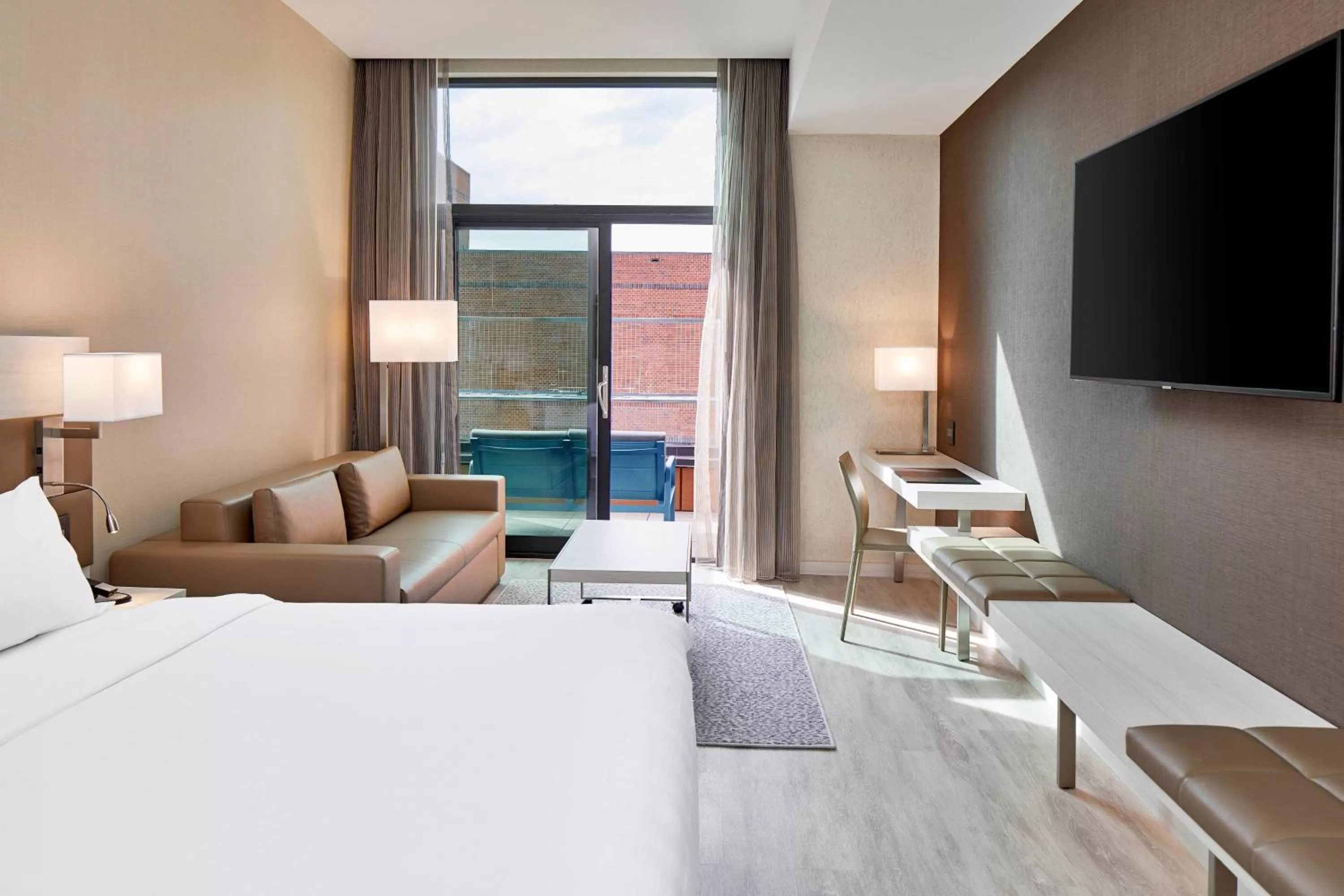 Guest room with king bed, sofa bed, balcony and city view in AC Hotel by Marriott Greenville